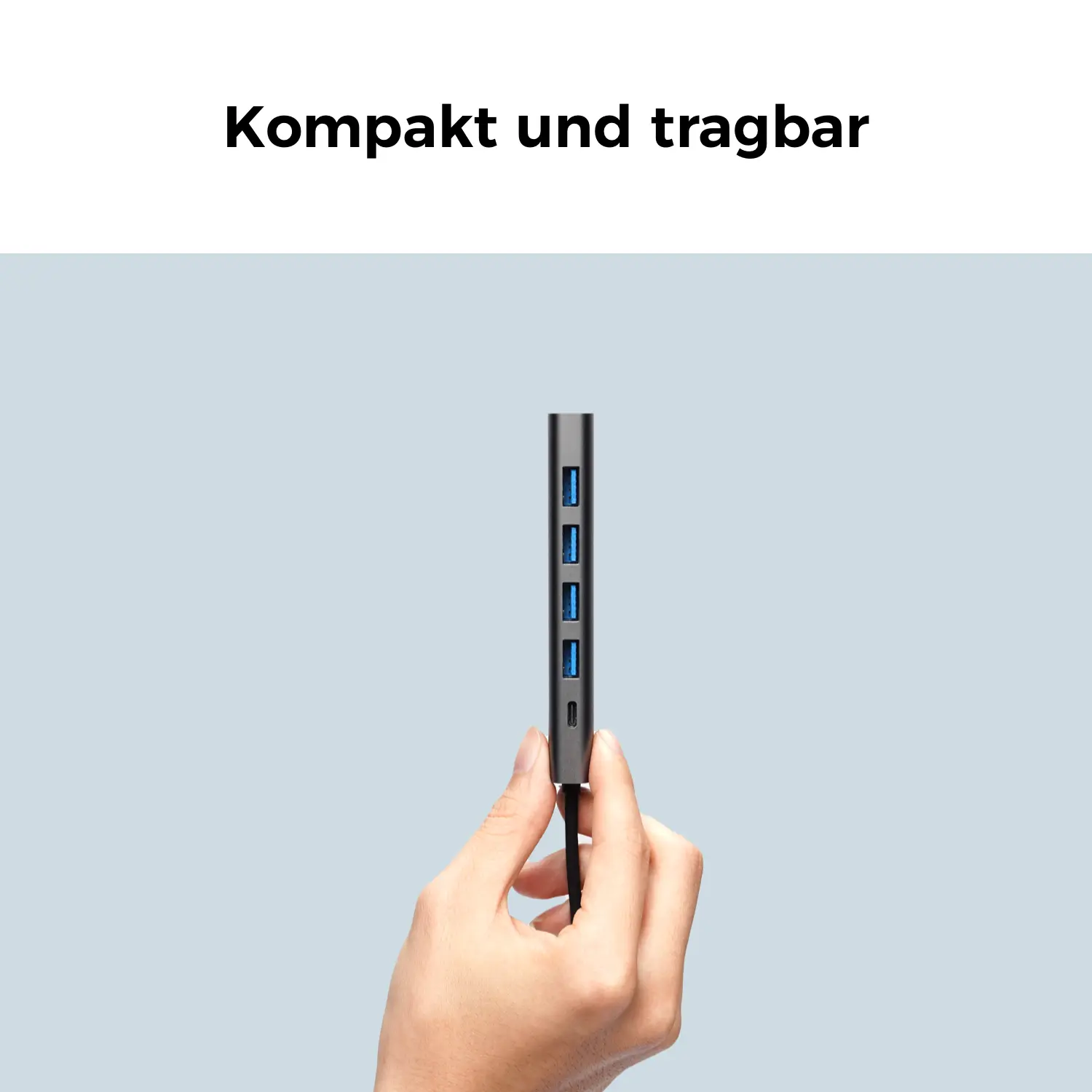 Une main tient un hub USB gris avec plusieurs ports.