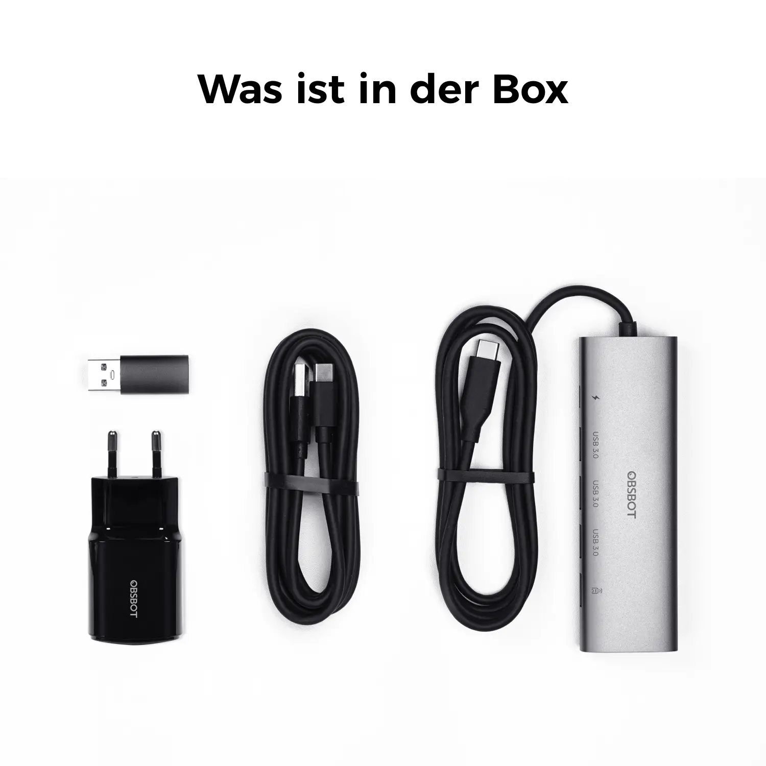 Un adaptateur secteur noir, deux câbles noirs et un hub USB-C argenté sur fond blanc.