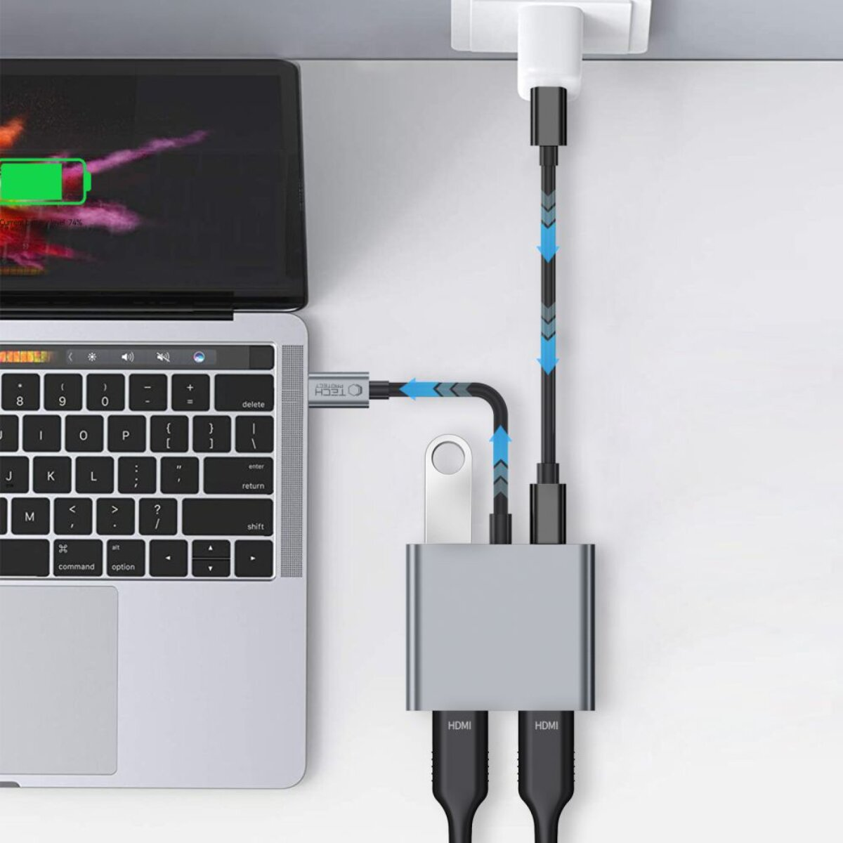 Un laptop si collega a un adattatore grigio con due cavi HDMI collegati.