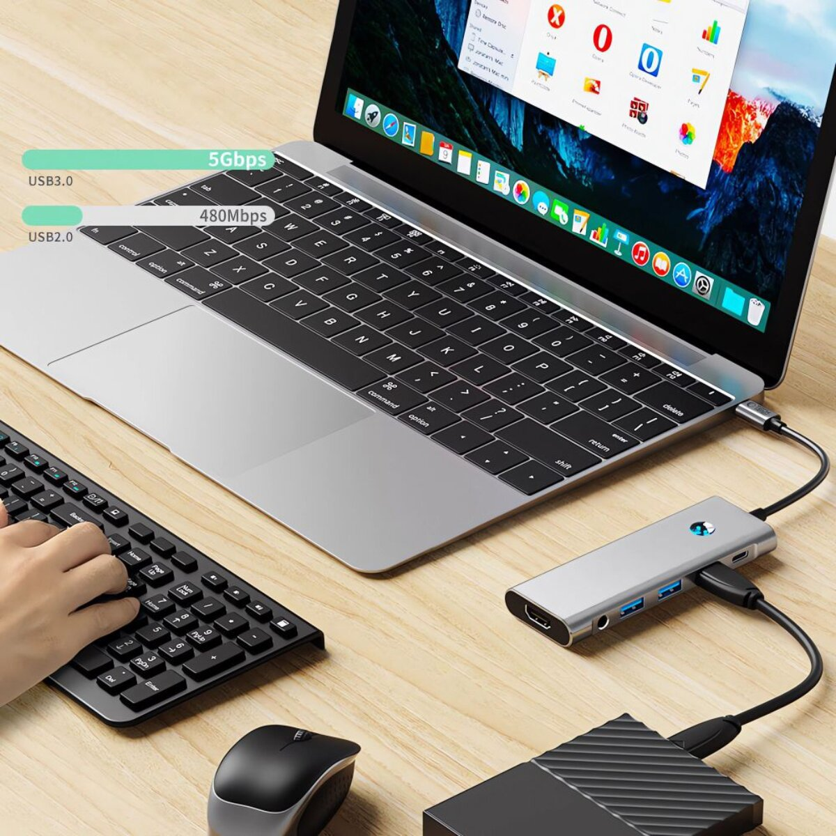 Laptop con hub USB, tastiera e mouse su scrivania in legno. USB 3.0 5Gbps.