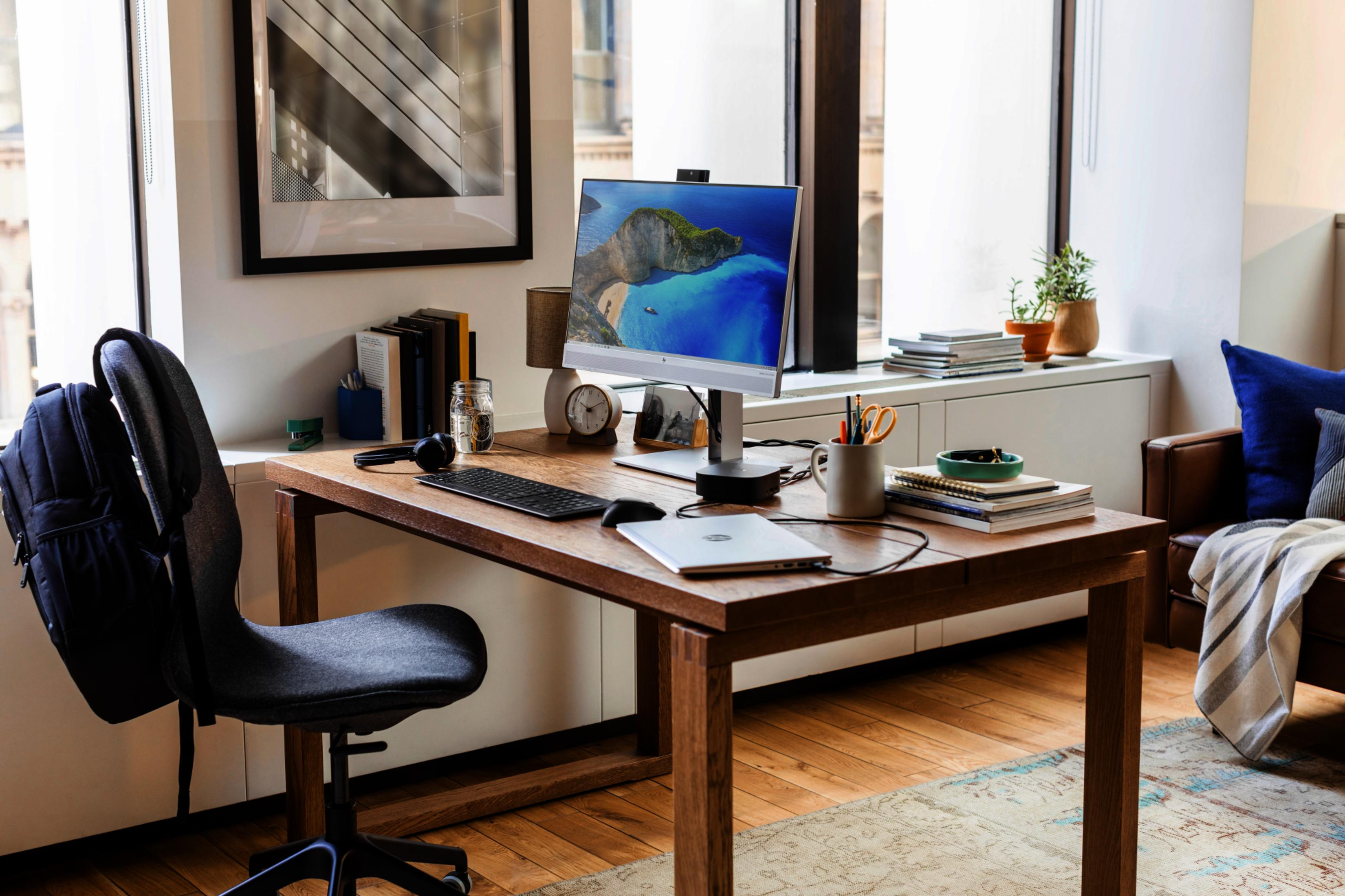 Ein Schreibtisch mit Computer, Tastatur, Maus, Laptop, Kopfhörern und Büromaterial.