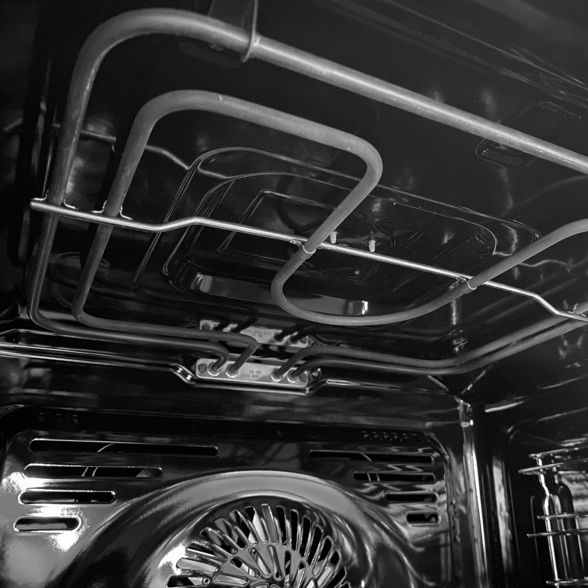 Vista interior de un horno con resistencias y ventilador.