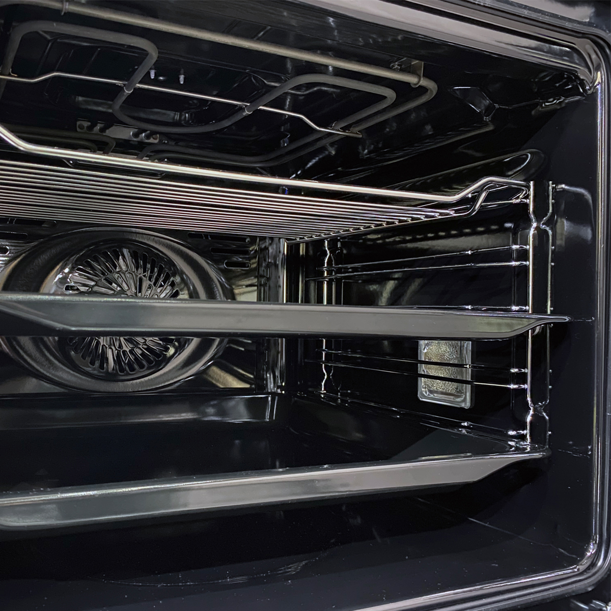 Interior de un horno moderno con ventilador, resistencias y rejillas.