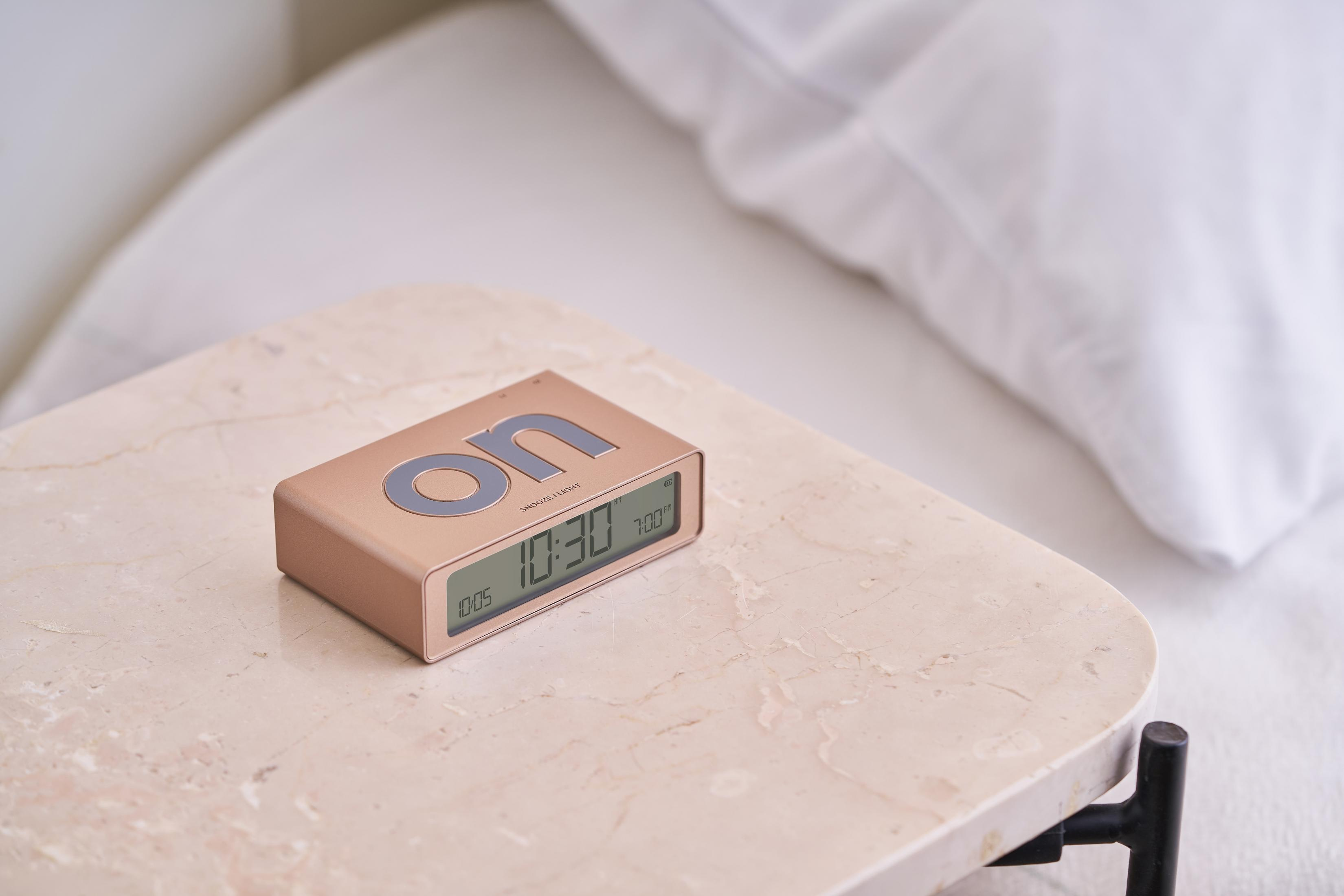 Ein bronzefarbener Wecker auf einem Marmortisch zeigt 10:30 Uhr an.