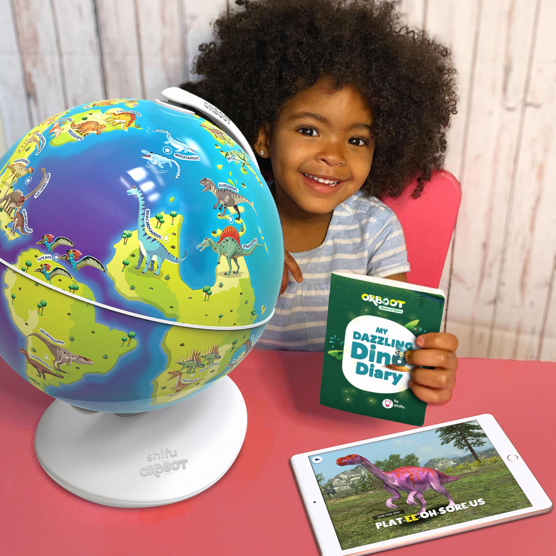 Una bambina sorride accanto a un globo con dinosauri e un tablet.