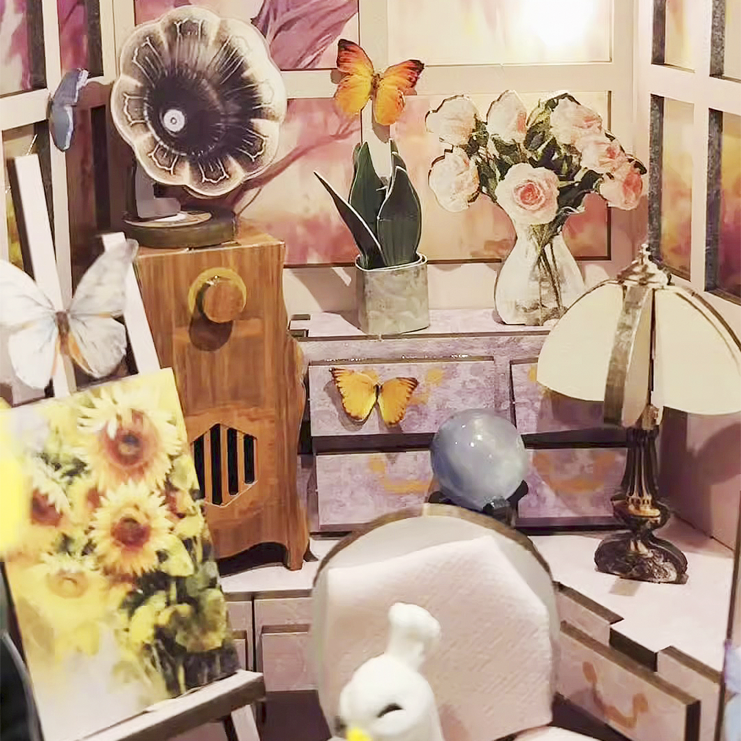 Set in miniatura: gramofono, fiori, farfalle, lampada, dipinto.