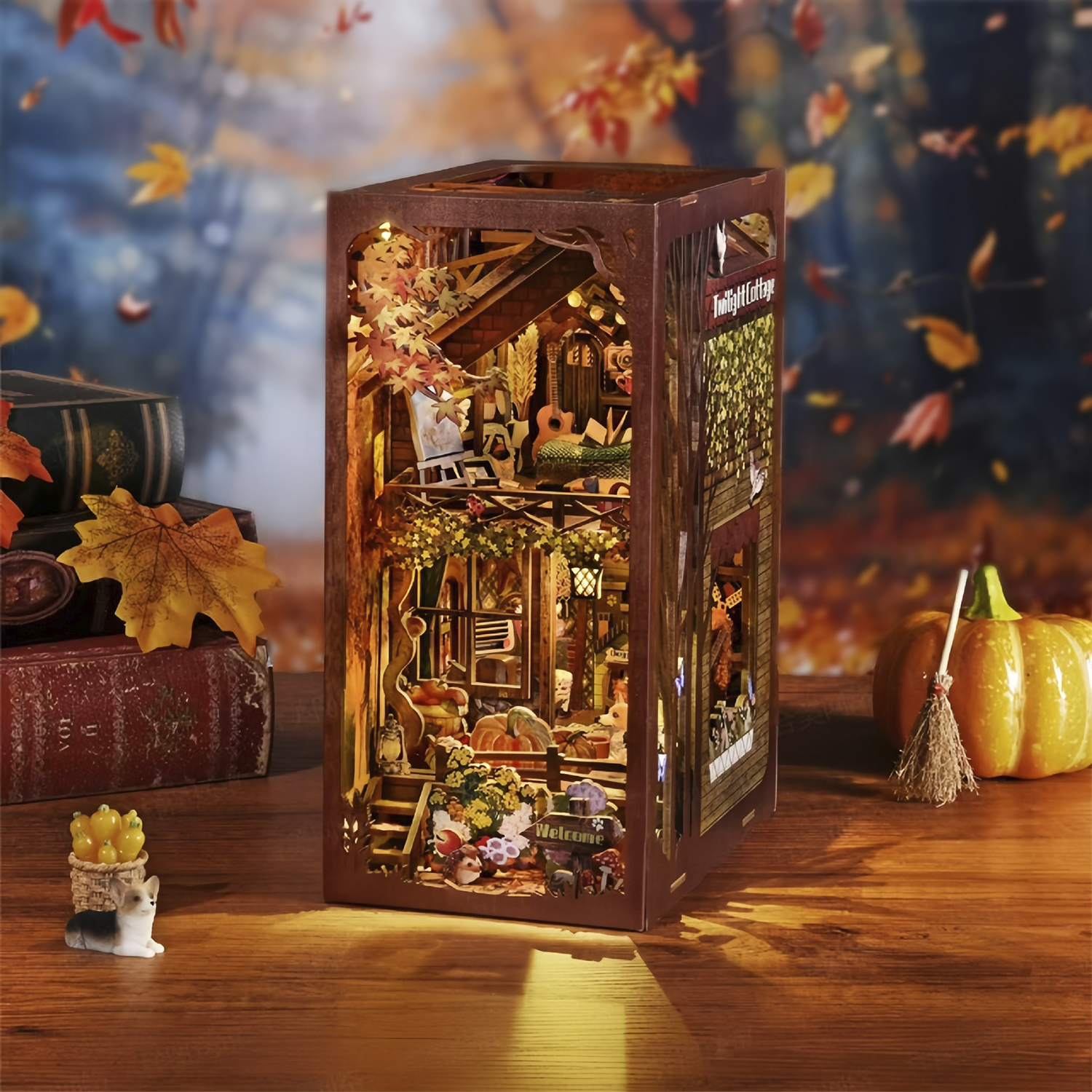 Casa in miniatura autunnale con zucca, scopa, libri e un gatto.