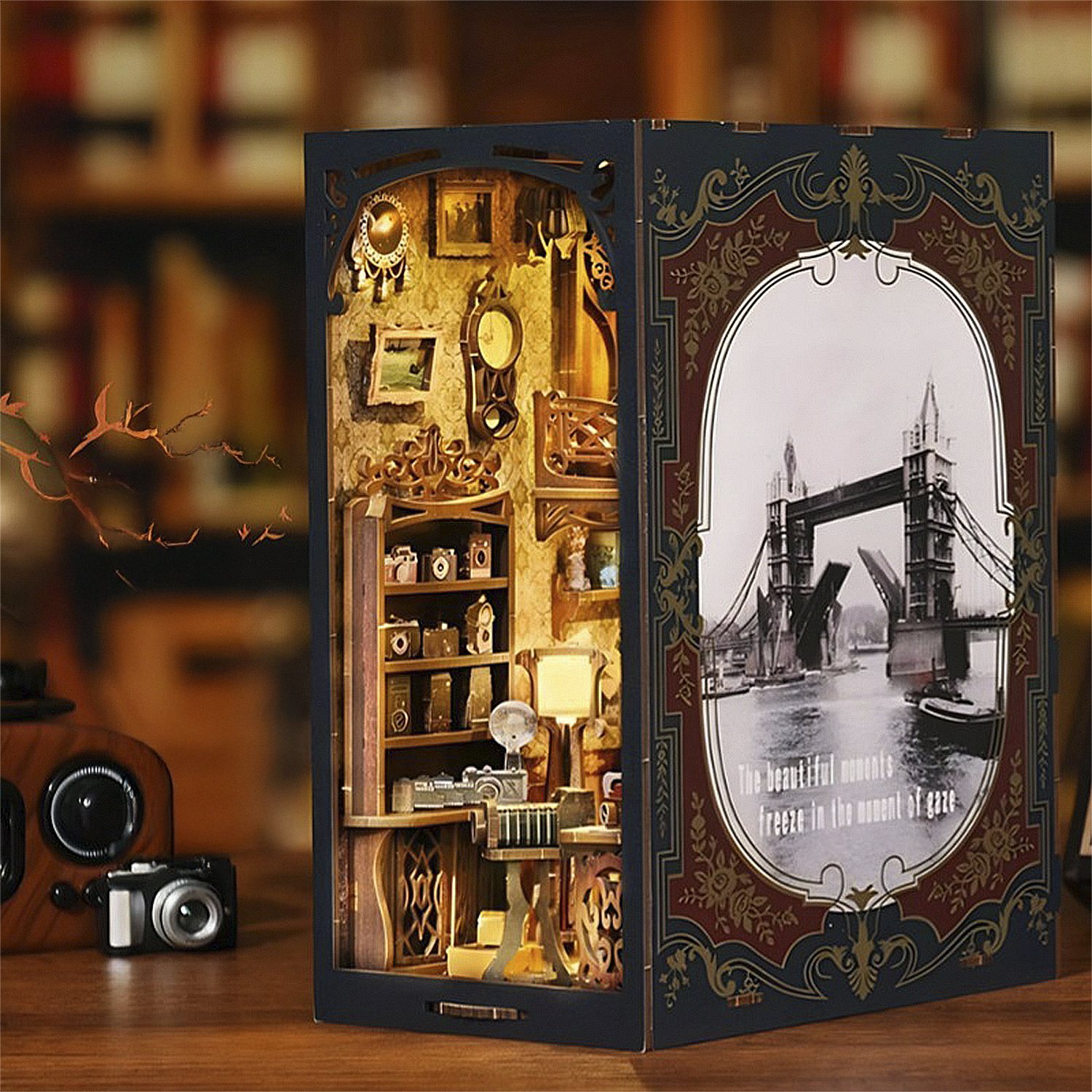 Una casita miniatura de rincón de libro con cámaras e imagen del Puente de Londres.
