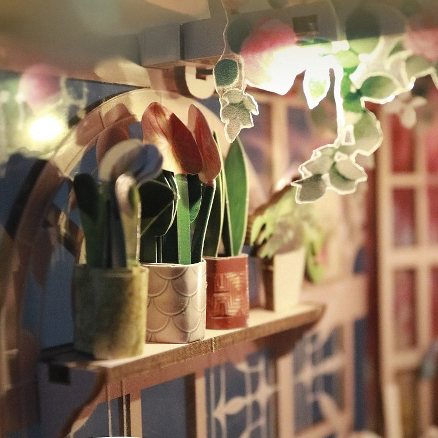 Tulipani in miniatura in vasi su uno scaffale con illuminazione di sfondo.