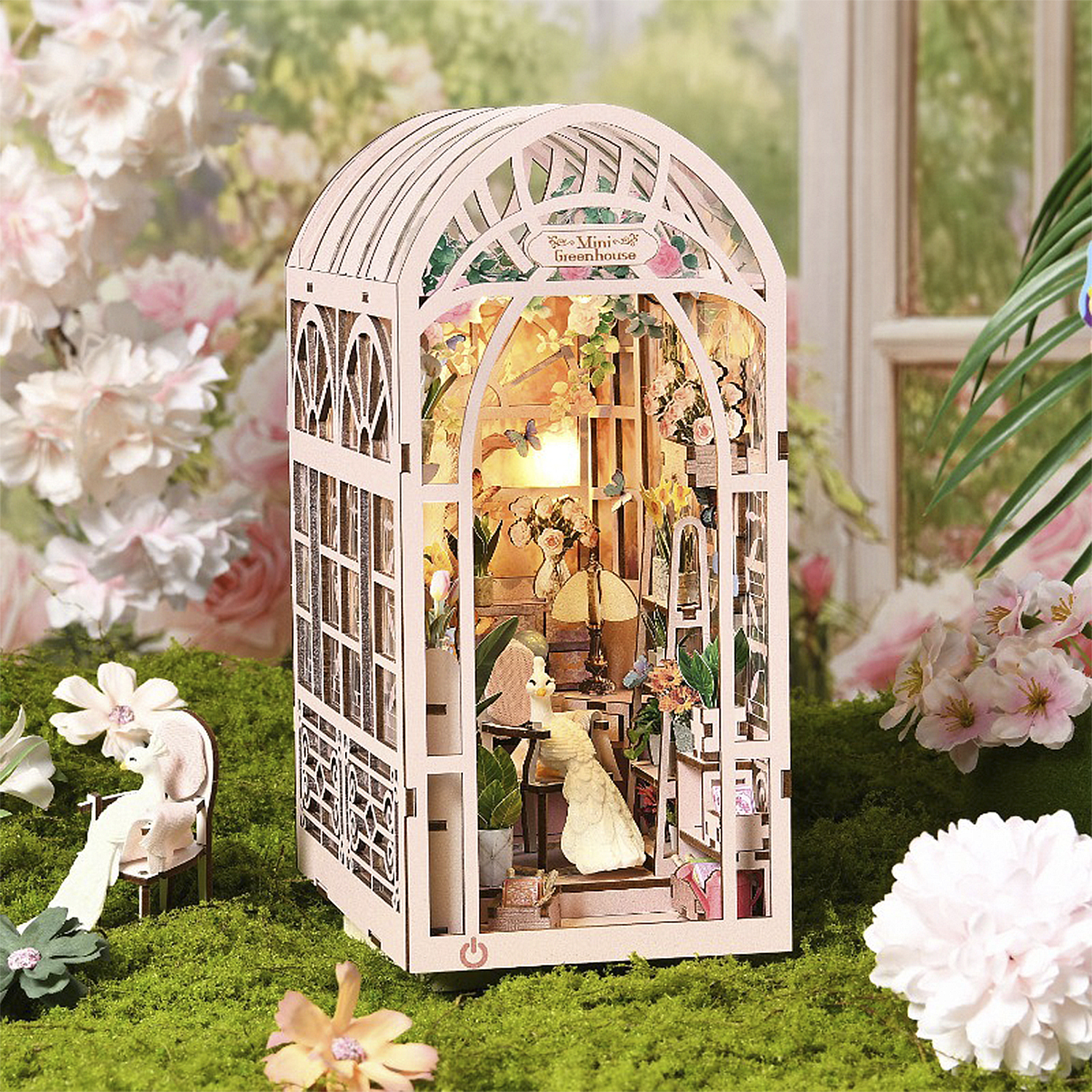 Una serra in miniatura di legno con mobili e fiori dettagliati.
