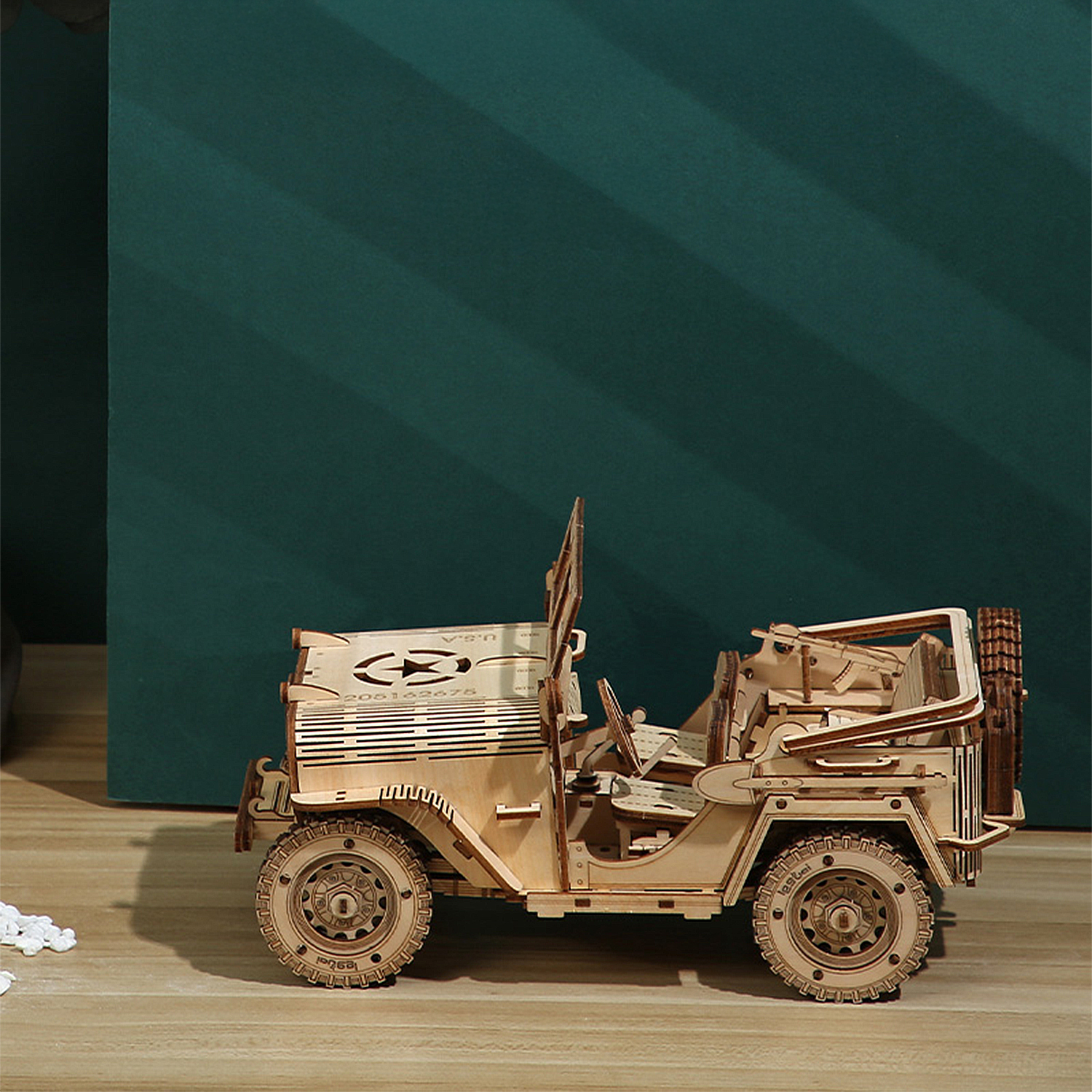 Un modello in legno di jeep scoperta su pavimento in legno.