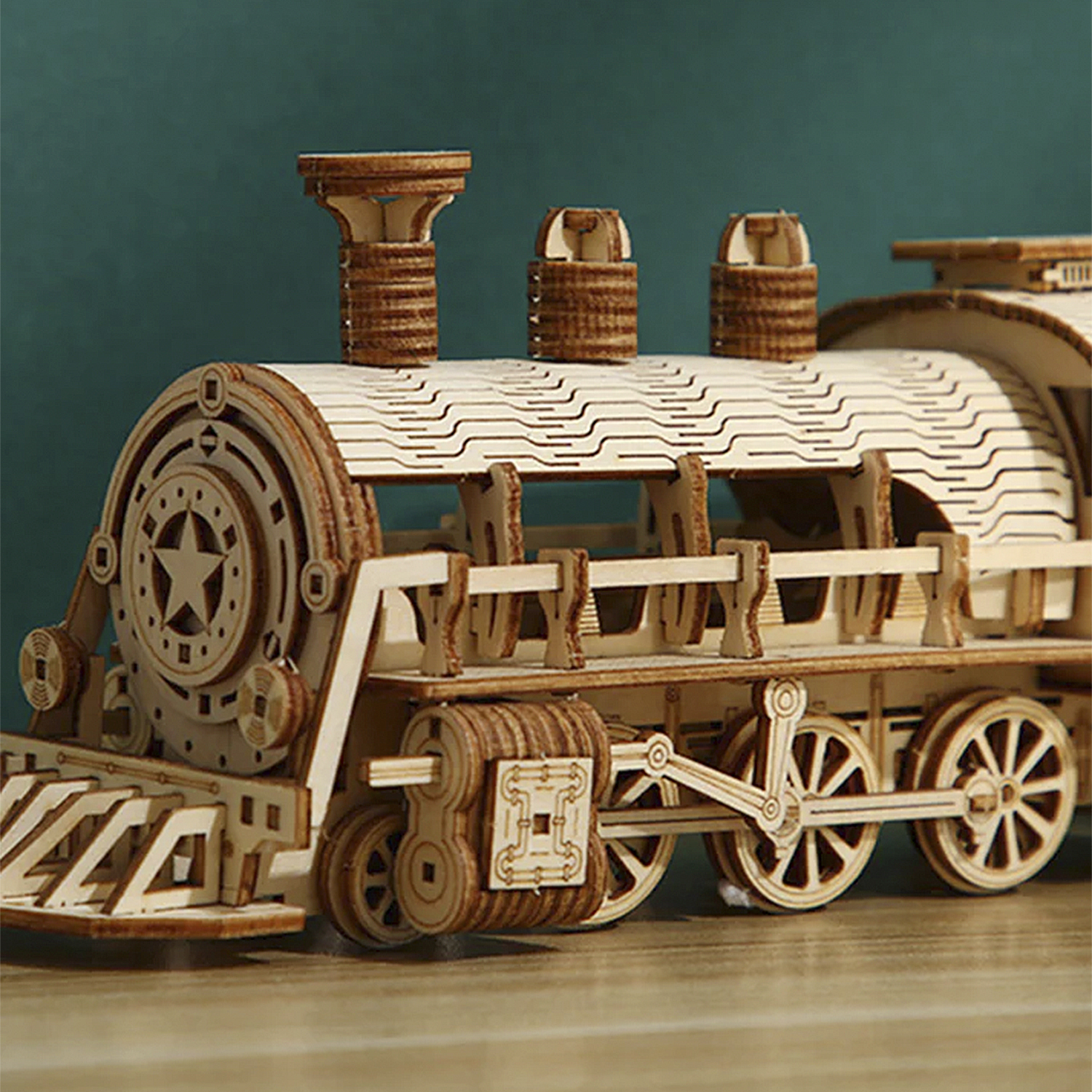Un modello in legno di una locomotiva a vapore con ruote e ciminiere dettagliate.