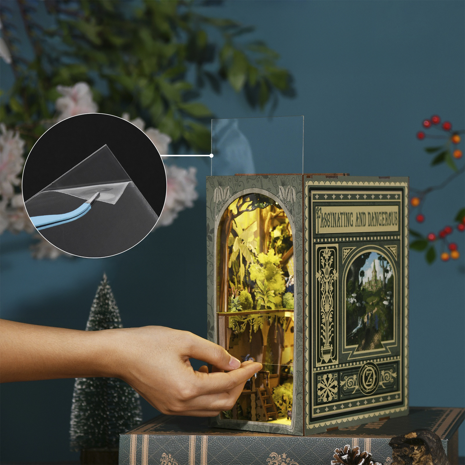 Mano che assembla un diorama libro con luci e dettaglio.