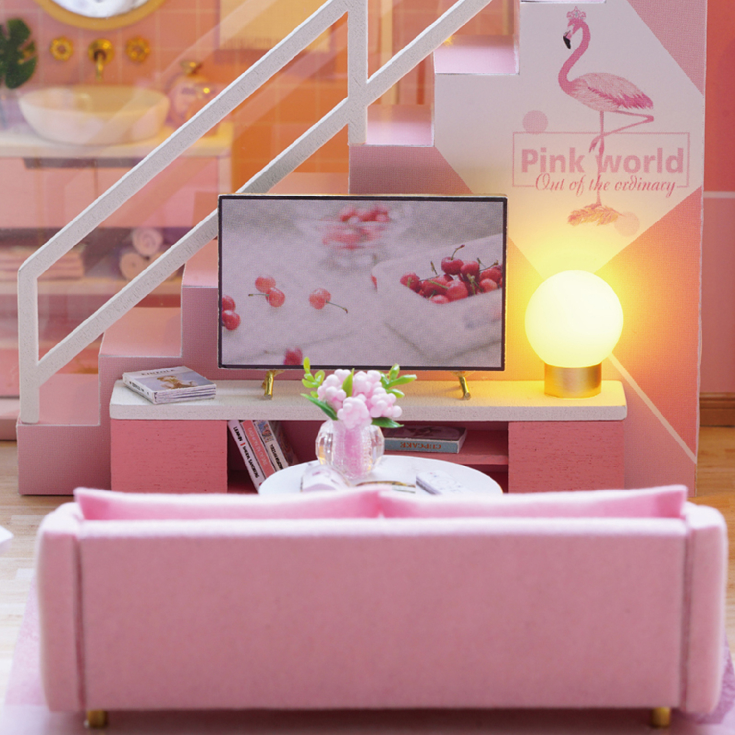 Un soggiorno in miniatura rosa con divano, TV e lampada. Ciliegie sullo schermo.