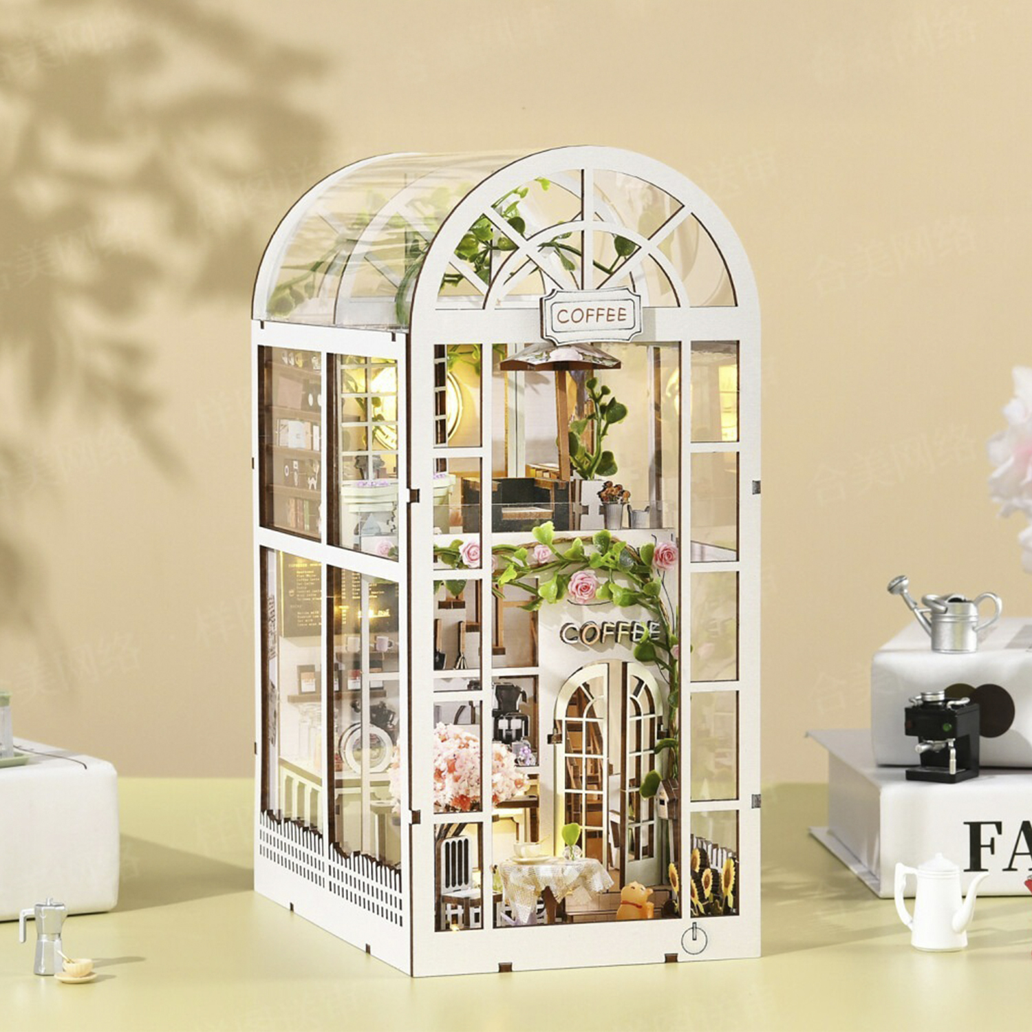 Modello in miniatura di caffetteria con tetto trasparente, fiori e mobili.