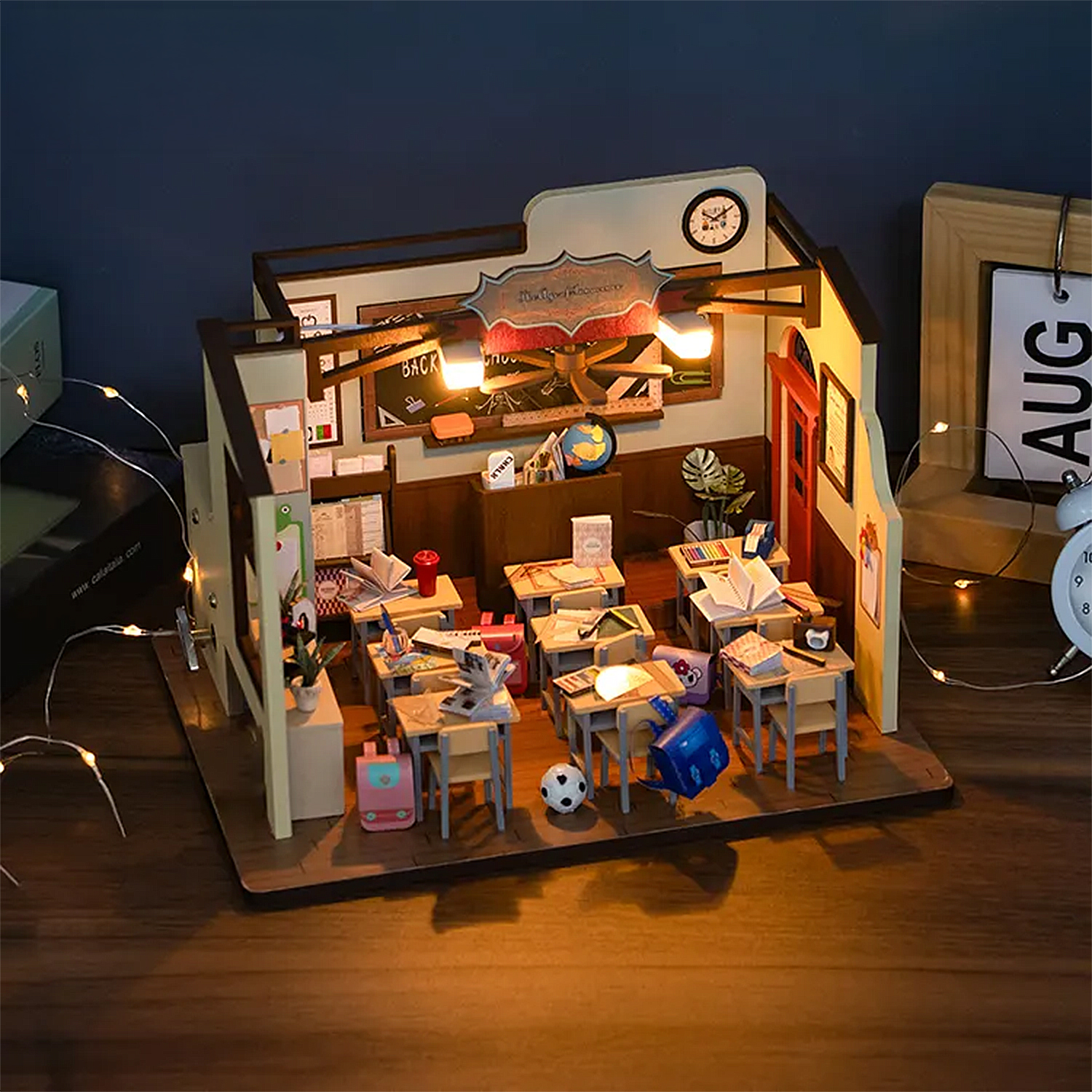Aula in miniatura con banchi, libri e decorazioni, illuminata.