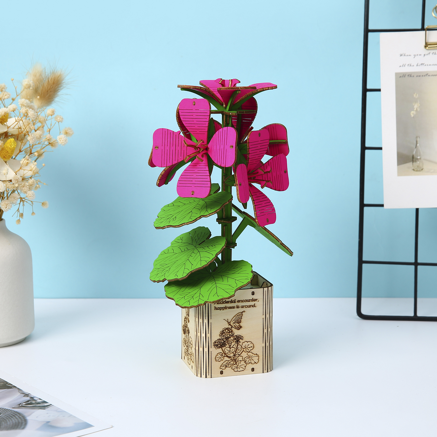 Modello di fiore in legno con fiori rosa e foglie verdi in un vaso.