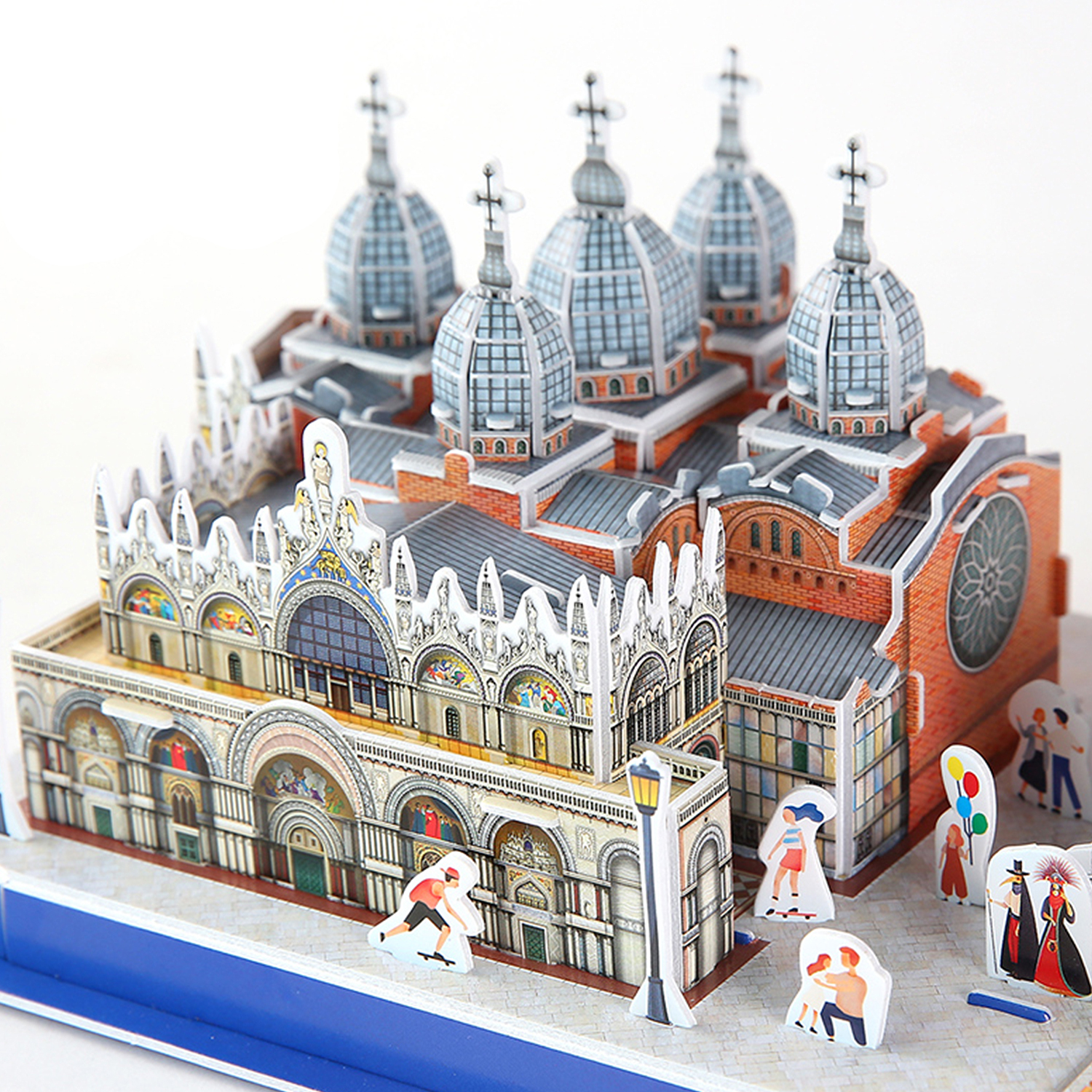 Modello di chiesa con cupole e piccole figure su sfondo bianco.