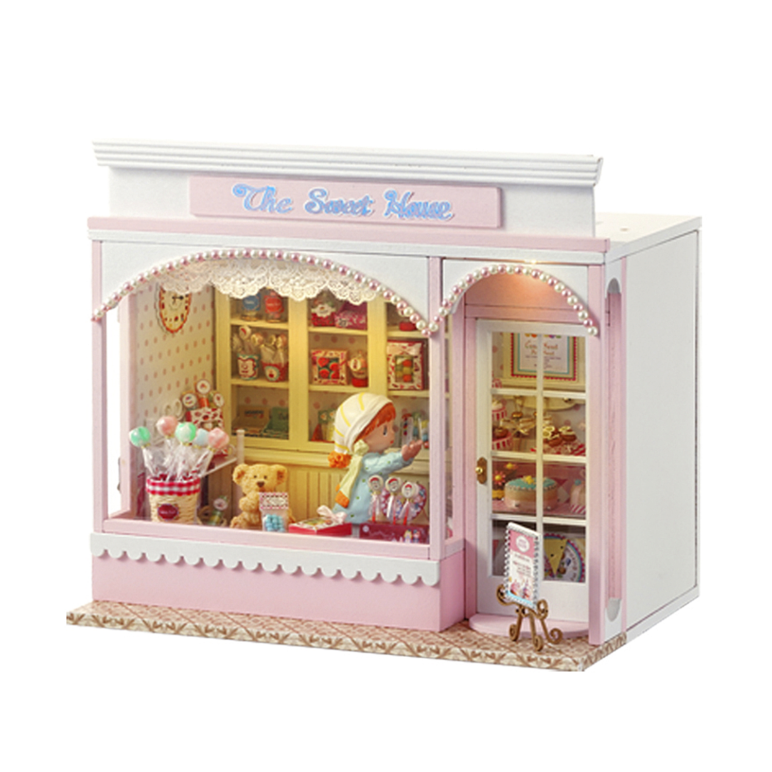Negozio di dolci in miniatura con bambola, orsacchiotto, lecca-lecca e torte.
