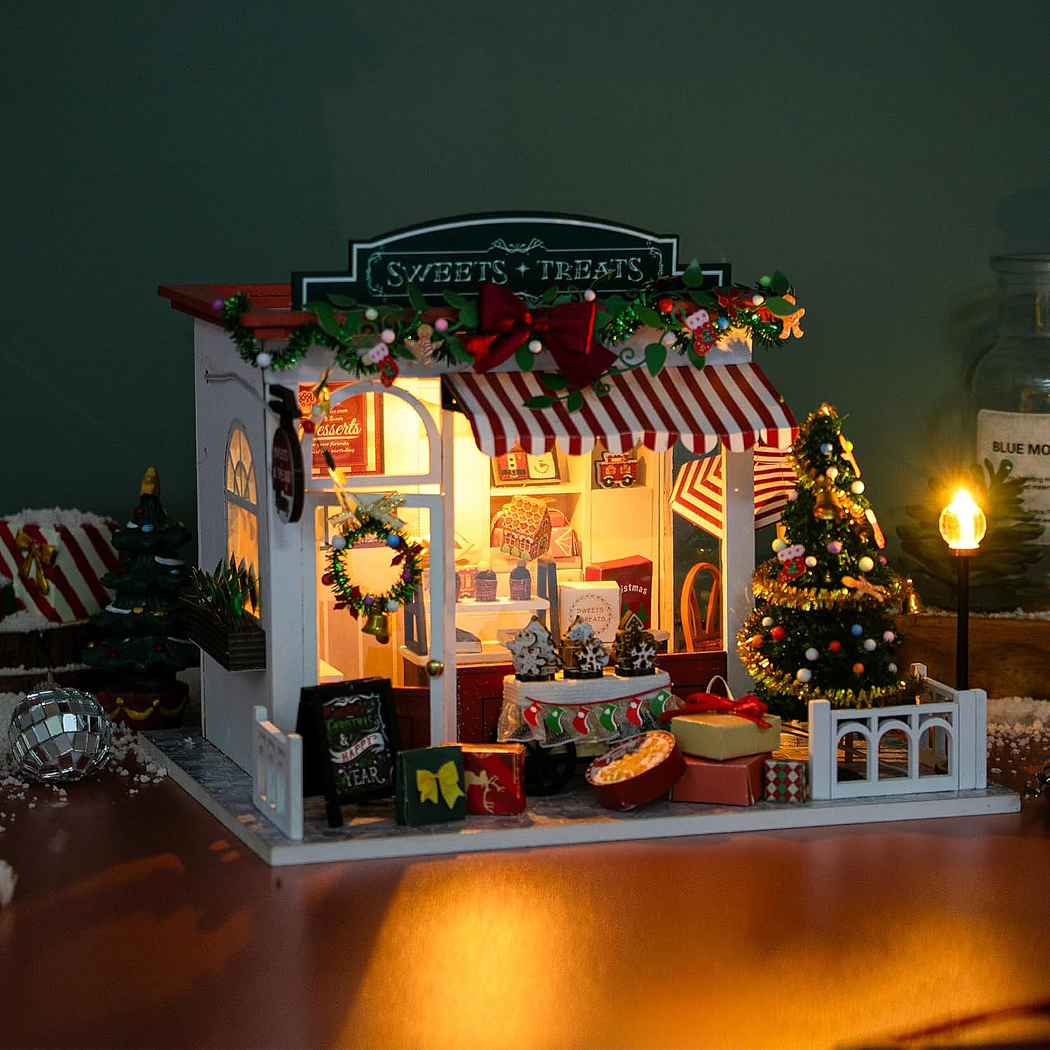 Mini negozio di dolci con decorazioni natalizie, luci e regali.