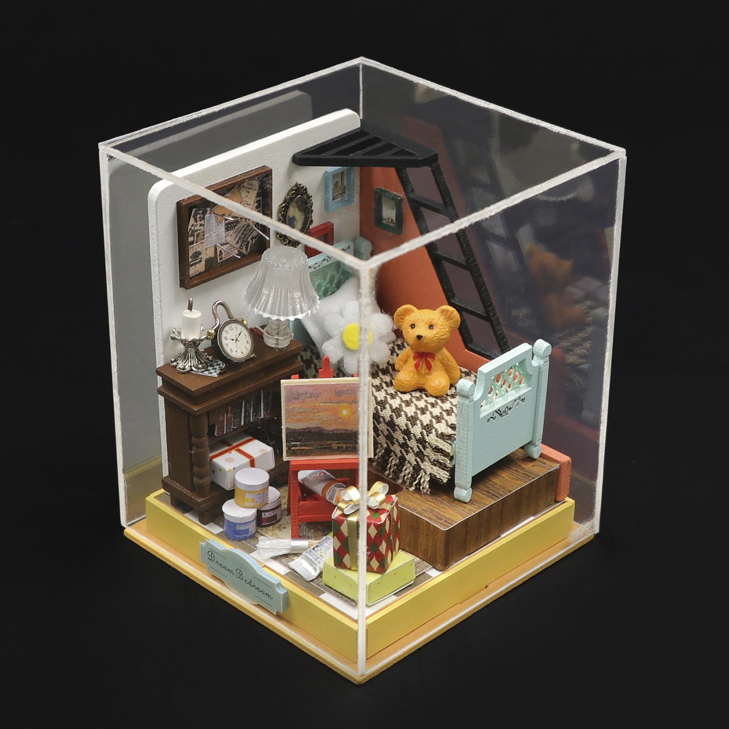 Una scena di camera da letto in miniatura con orsacchiotto sul letto, scrivania e forniture artistiche.