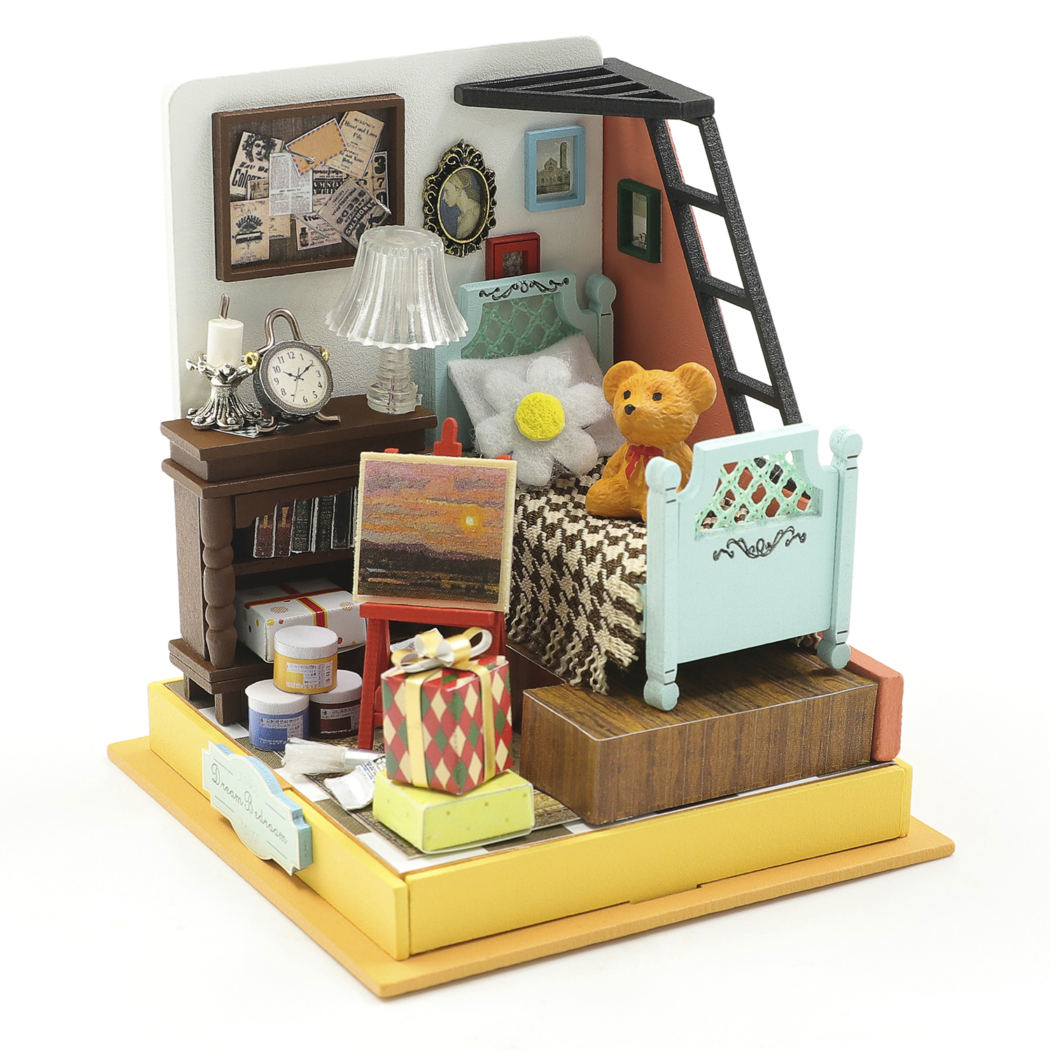 Camera in miniatura con letto, orsacchiotto, lampada, orologio e materiale artistico.