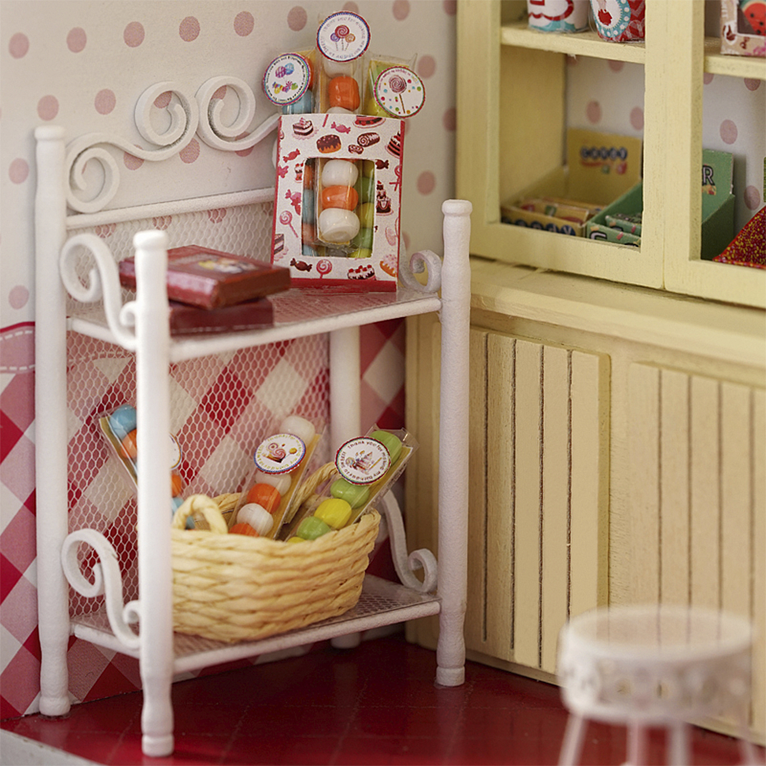Scaffale di caramelle in miniatura con caramelle colorate, biscotti e un cesto intrecciato.