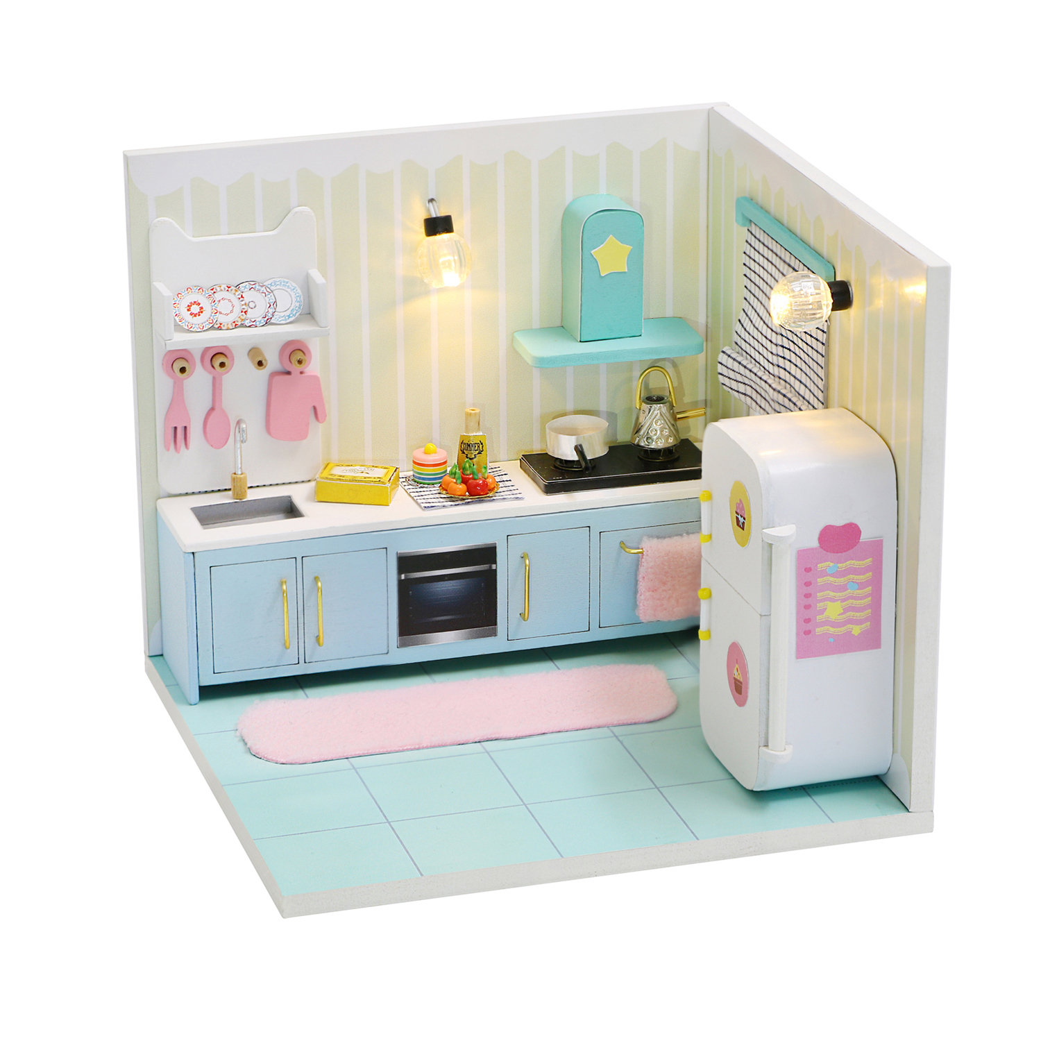 Cucina in miniatura con mobili blu, frigorifero e utensili.