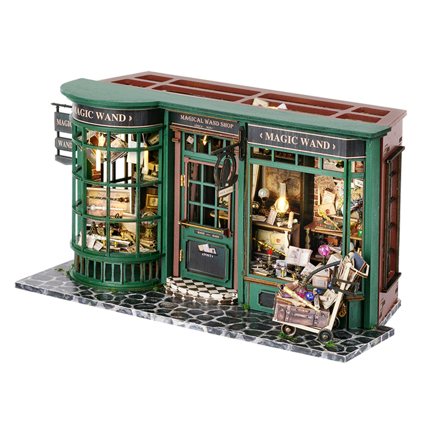 Negozio miniatura di bacchette magiche verdi con vetrine e carretto carico.