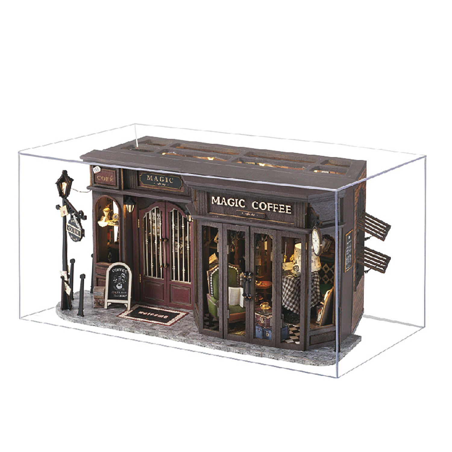 Caffetteria in miniatura con insegna "Magic Coffee", lampada accesa e area salotto.
