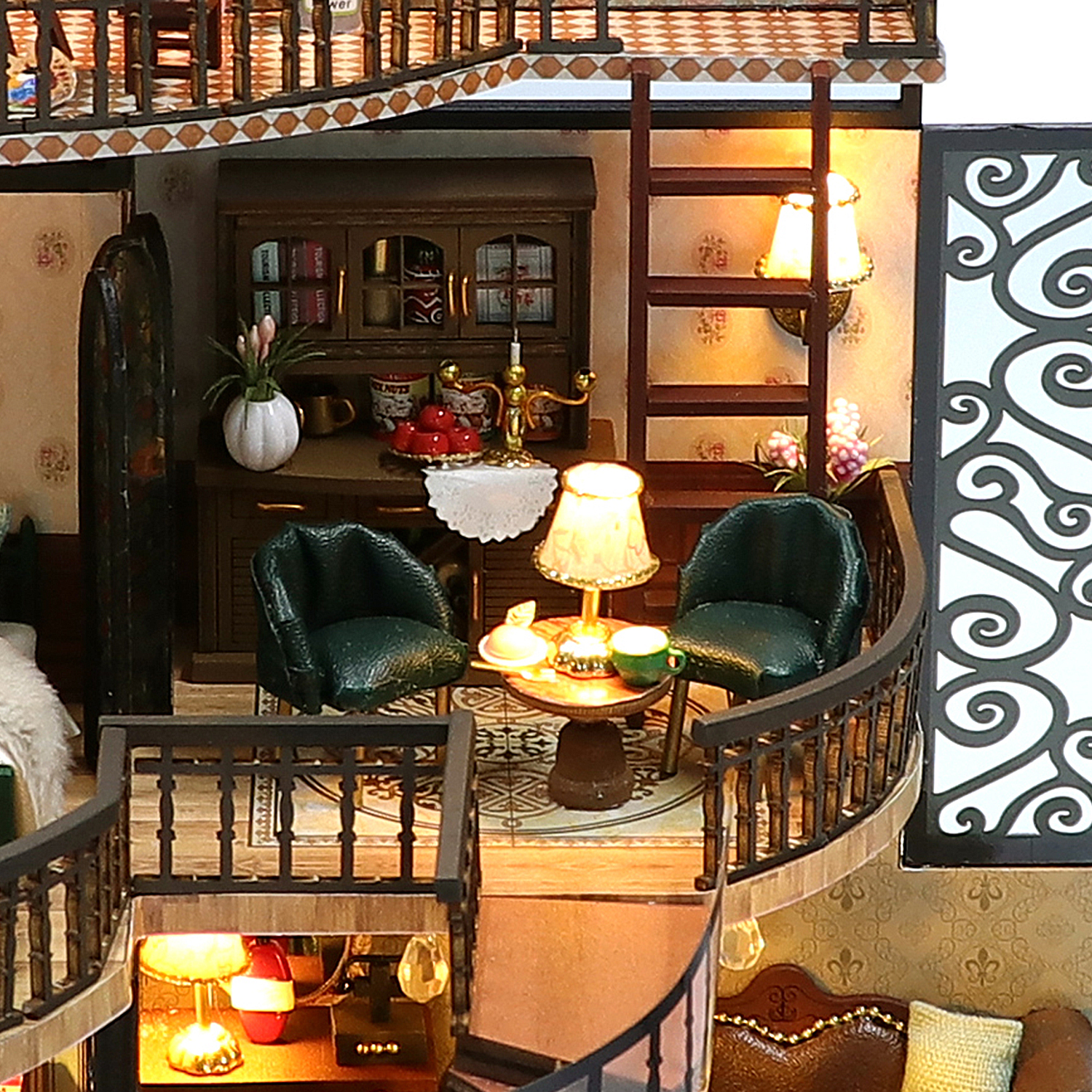 Soggiorno in miniatura con due poltrone verdi, tavolo, lampada e scala.