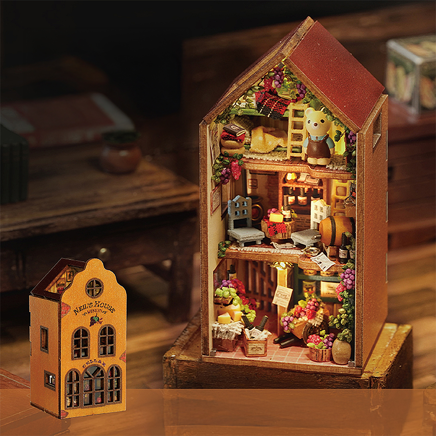 Casa in miniatura con figura d'orso, uva e mobili. Illuminata dall'interno.