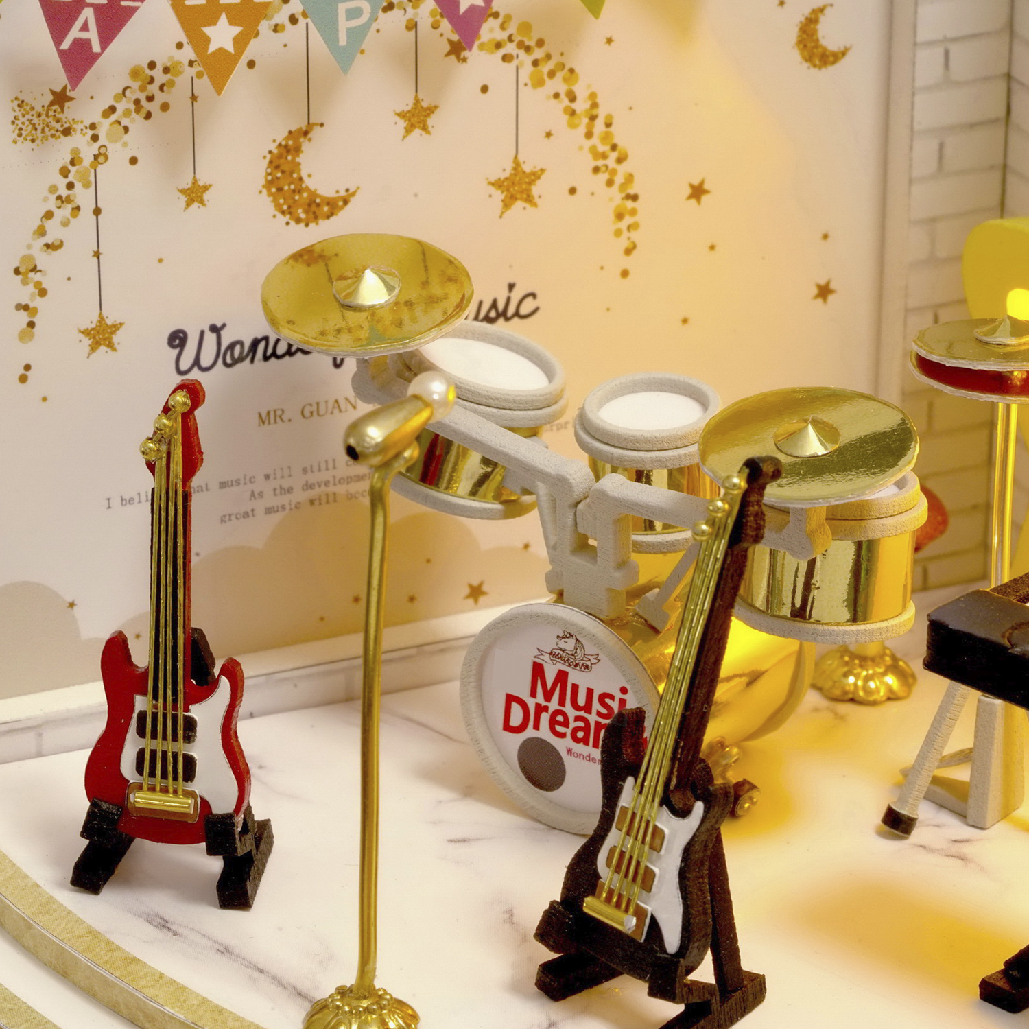 Mini set musicale con chitarre, batteria e microfono su un palco.