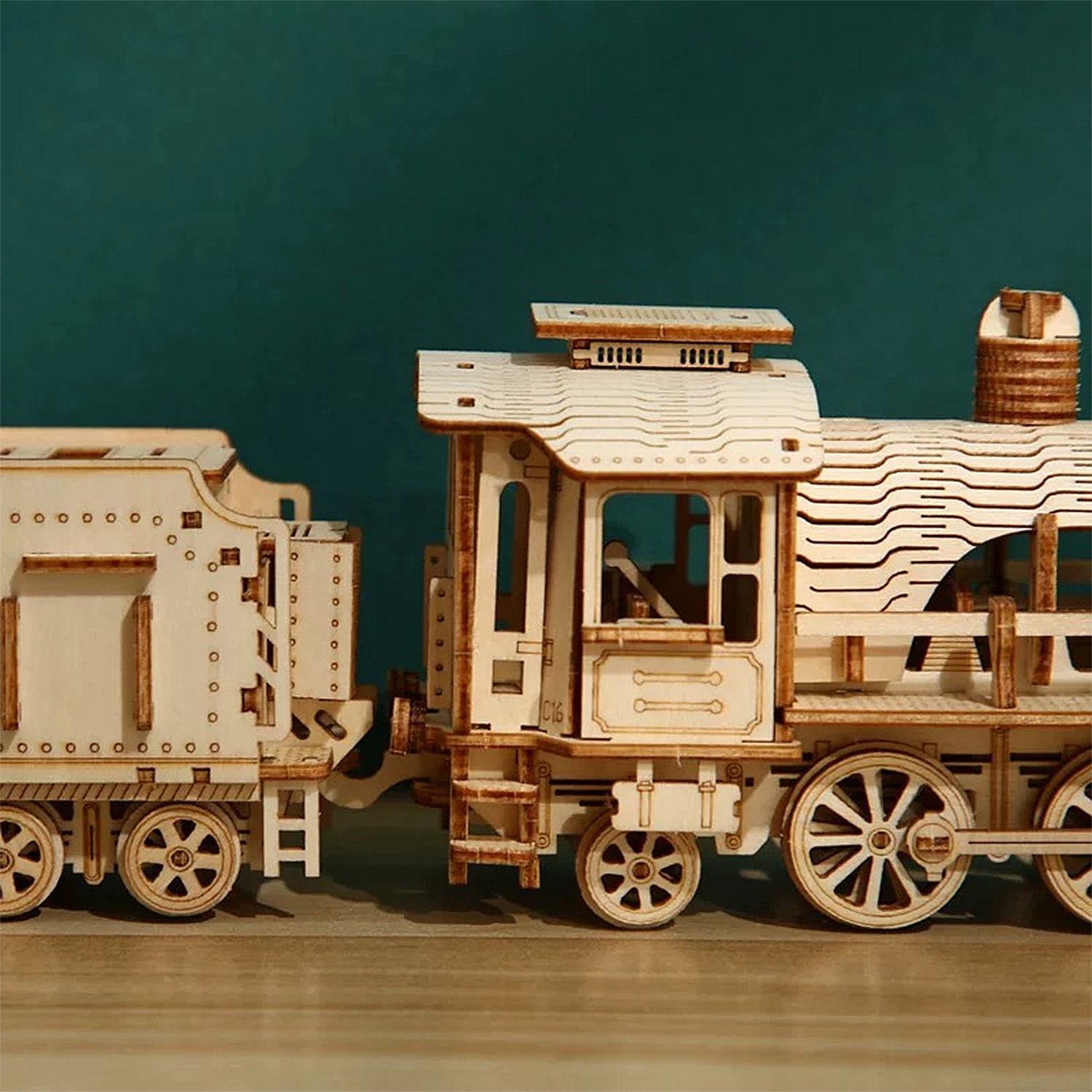 Modello in legno di una locomotiva a vapore con tender, dettagliato, su tavolo.