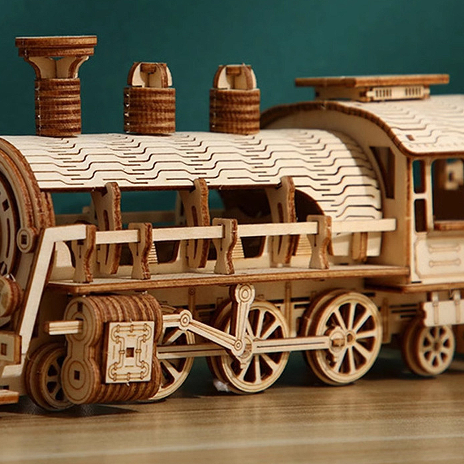 Un modello in legno di una locomotiva a vapore con ruote e ciminiere.