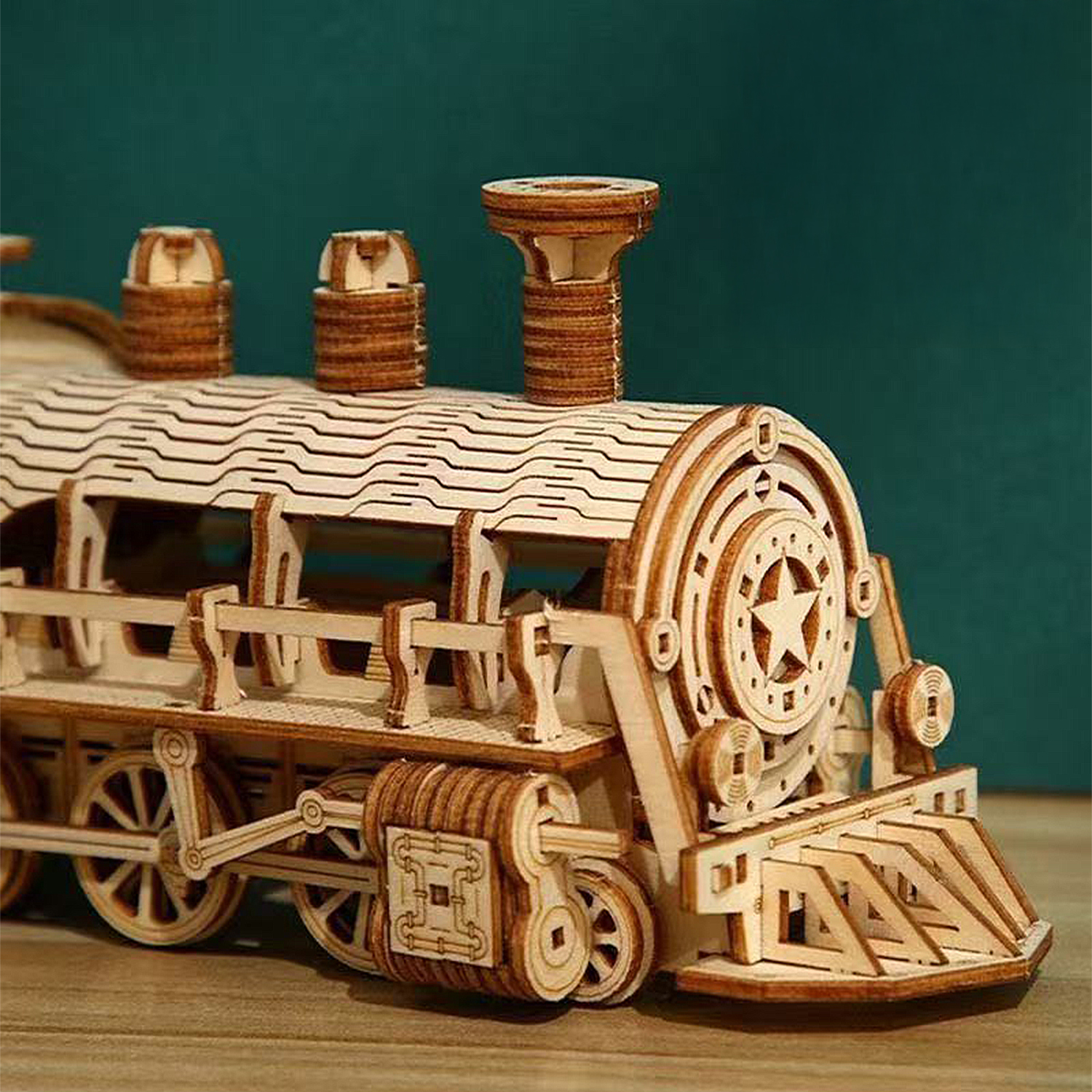 Un dettagliato modello in legno di una locomotiva a vapore con ruote e ciminiere.