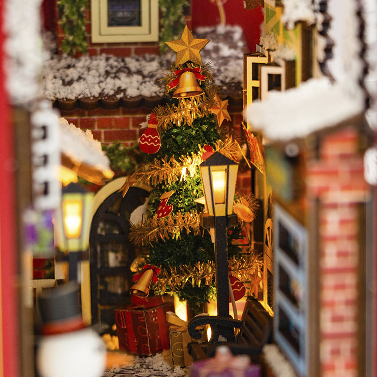 Un albero di Natale in miniatura con luci, regali e un pupazzo di neve.