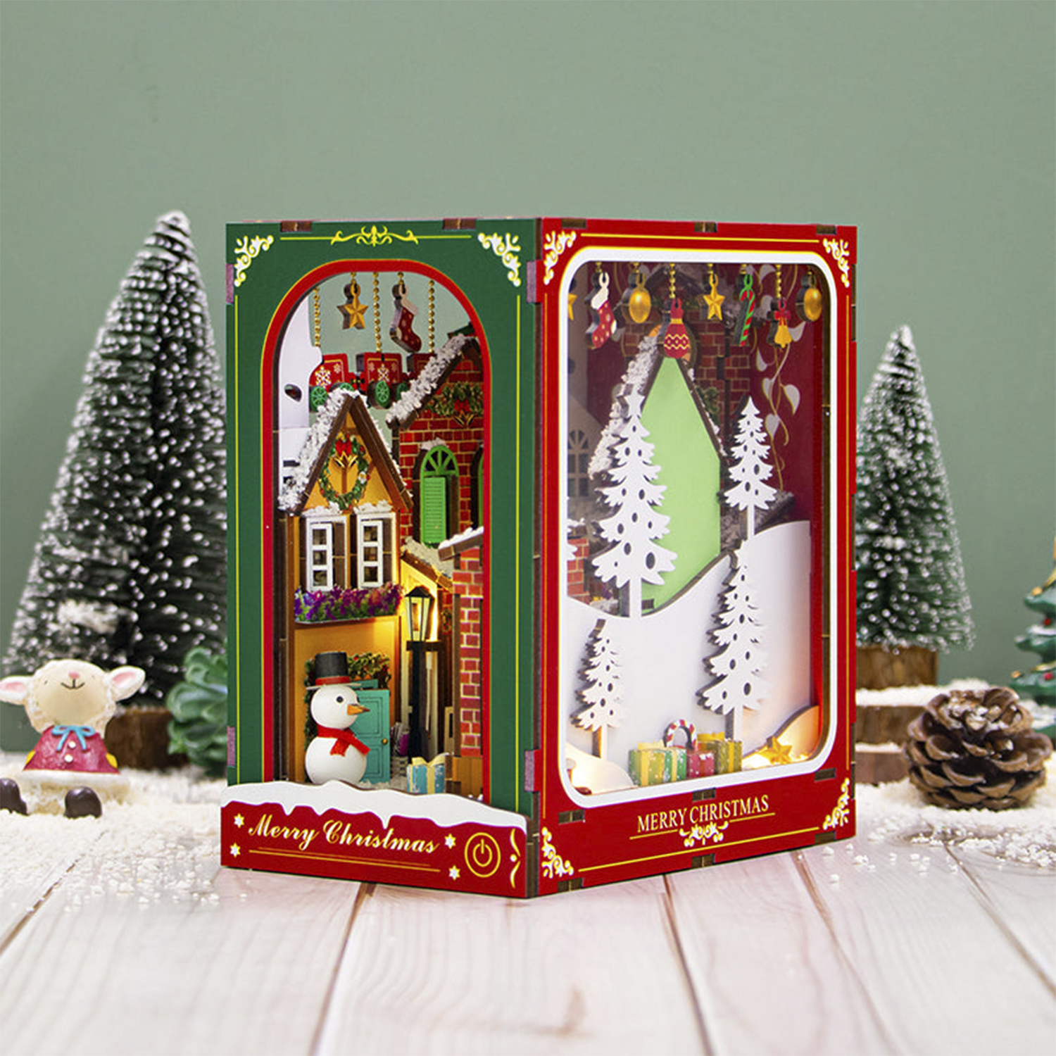 Diorama natalizio con pupazzo di neve, alberi e regali.