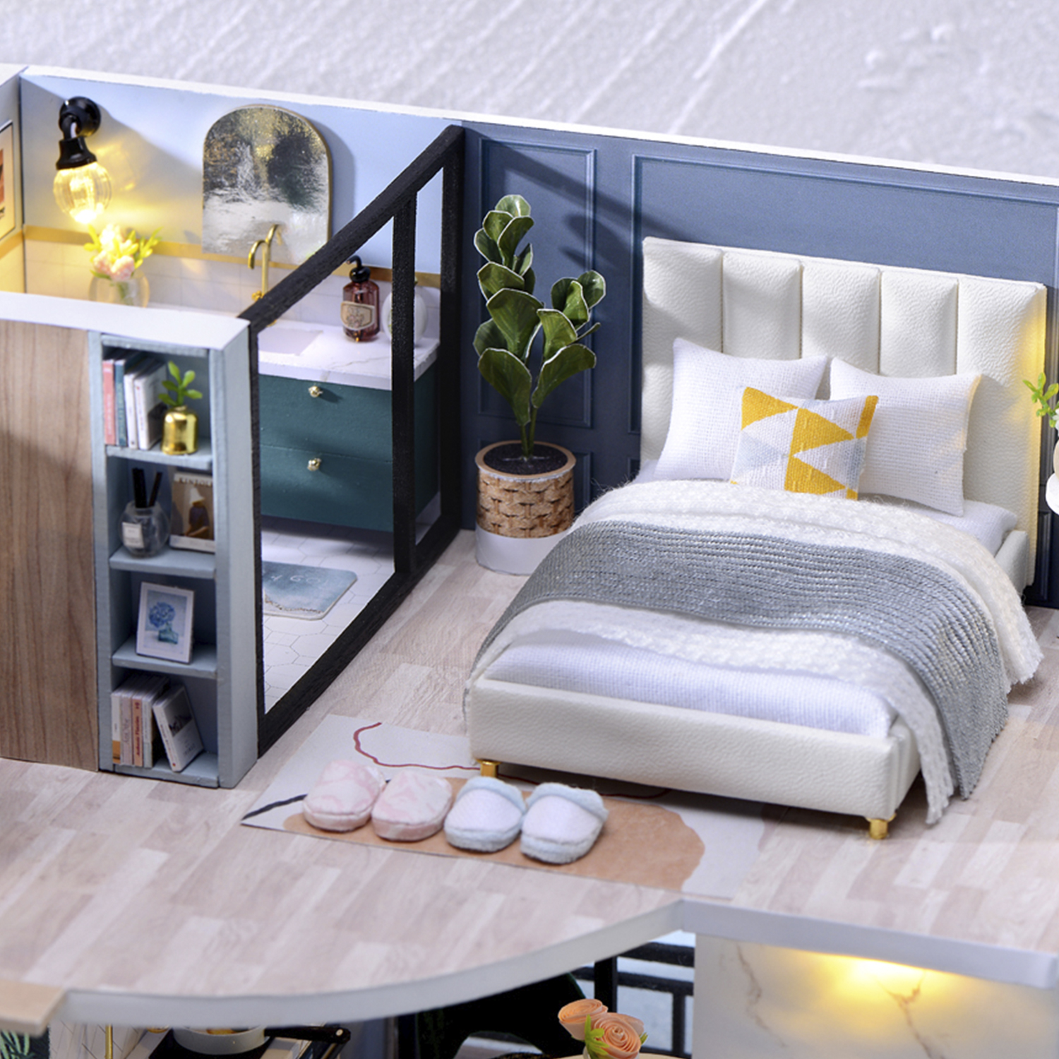 Scena di camera da letto in miniatura con letto, bagno e libreria.