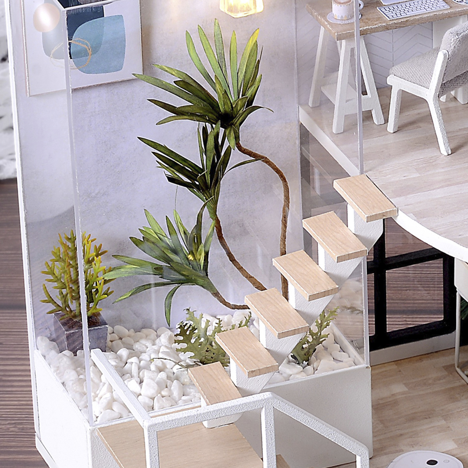 Interno di casa in miniatura con piante, scale e scrivania.