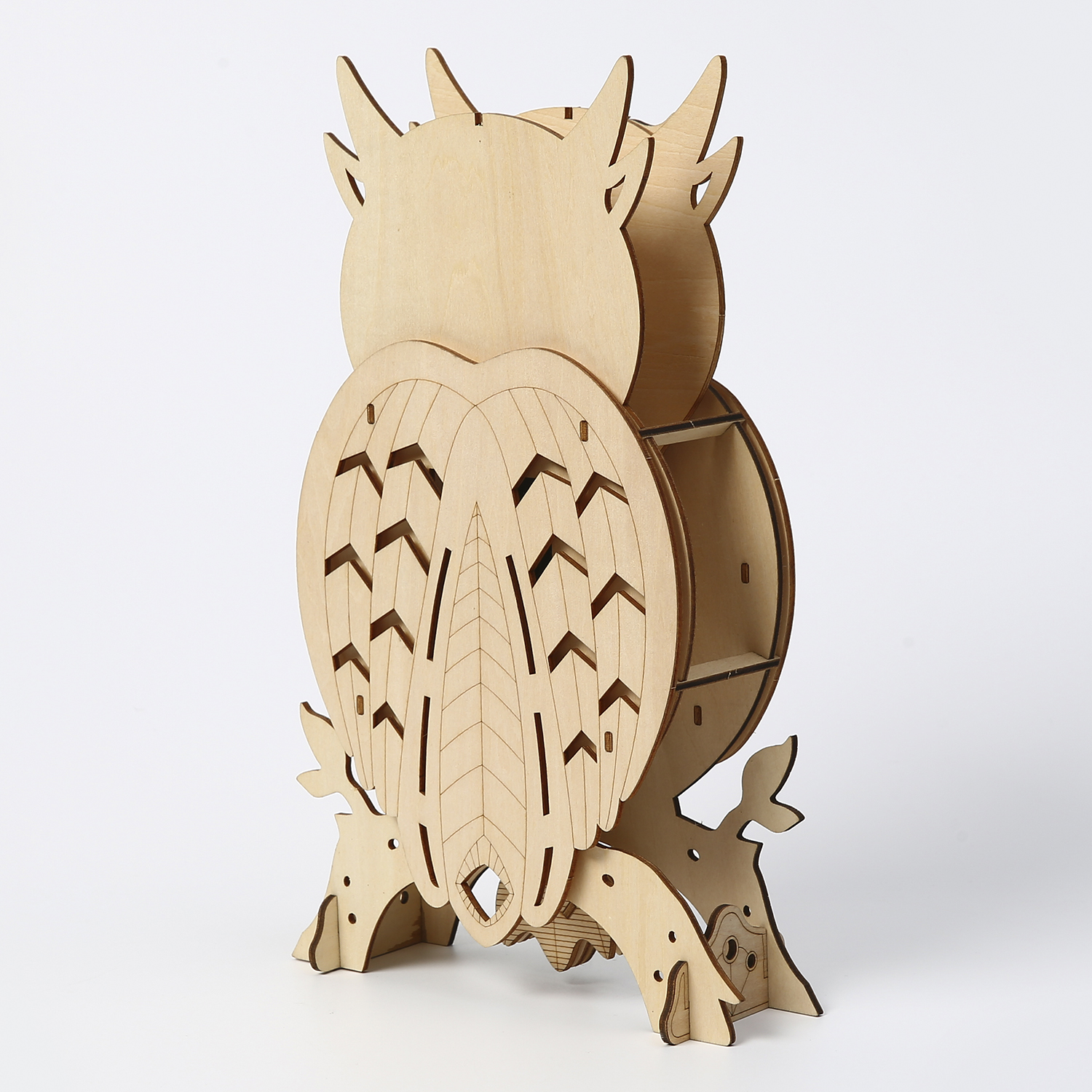 Un espositore a forma di gufo in legno con motivi geometrici, in piedi su un ramo.