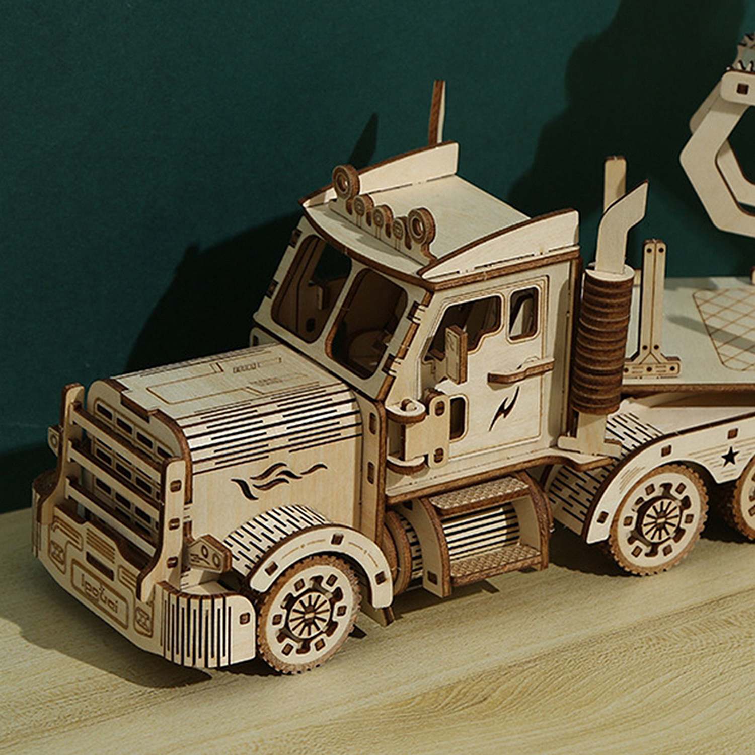 Un dettagliato modello in legno di un camion con gru si trova su un tavolo di legno.