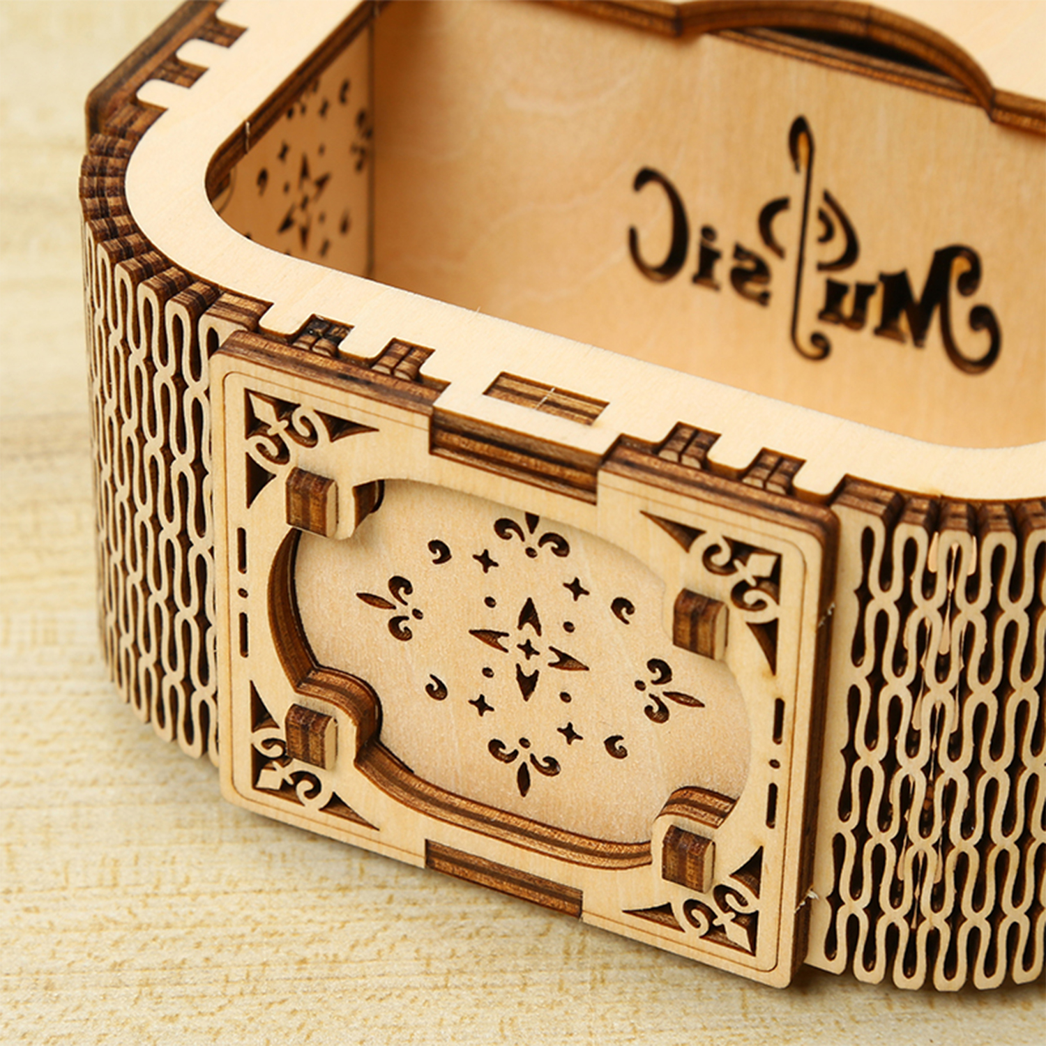 Un contenitore in legno intagliato con motivi intricati e la parola "Music".