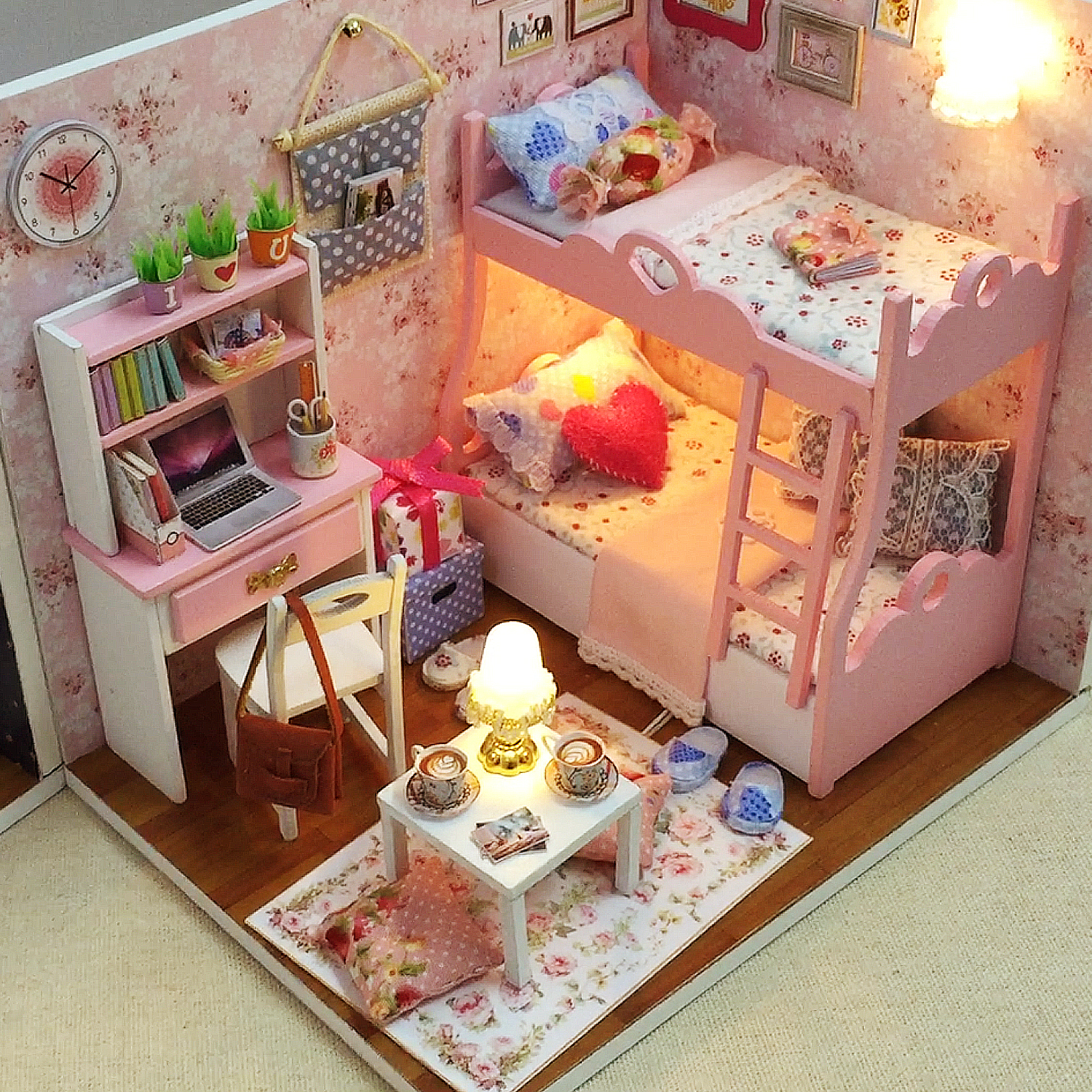 Camera da letto in miniatura con letto a castello, scrivania, tappeto e lampada.