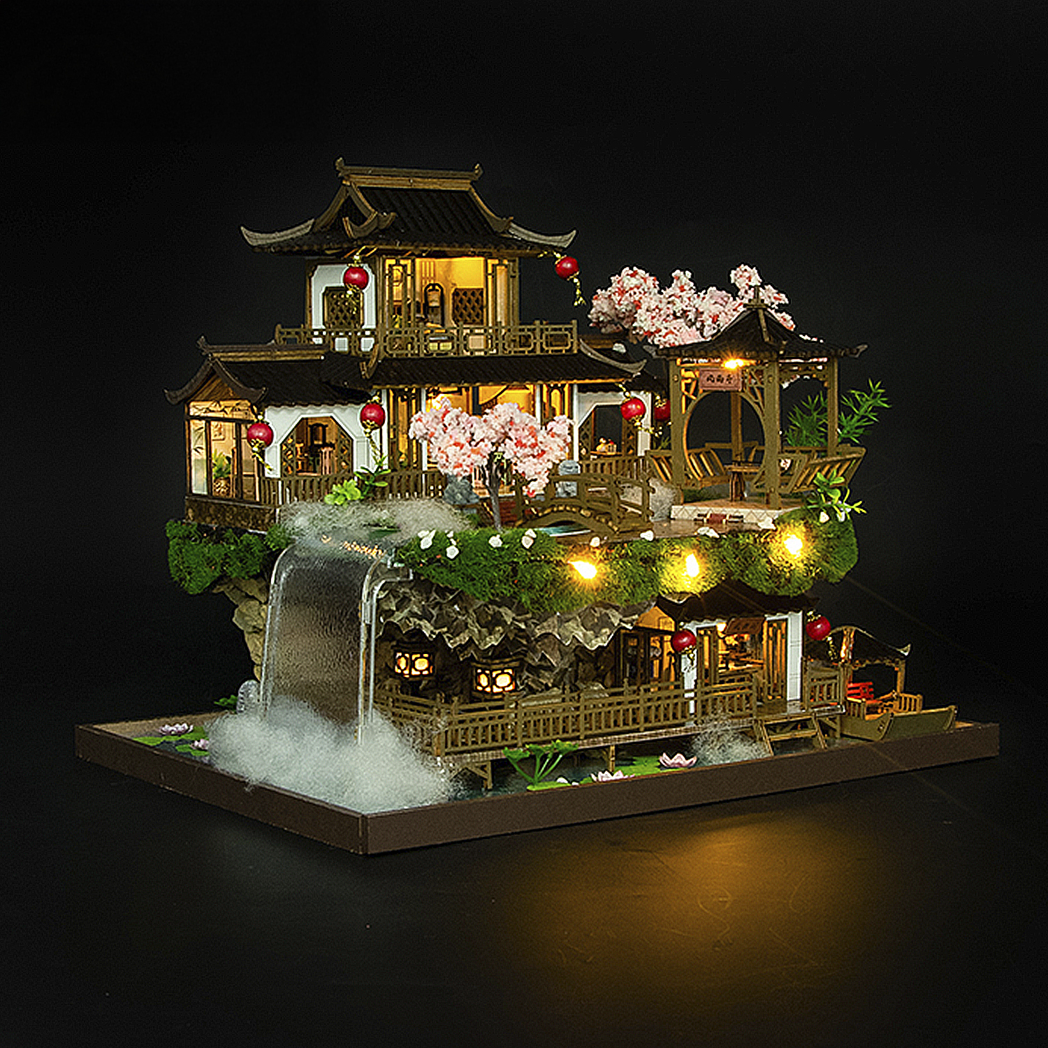 Una casa in miniatura a più piani in stile asiatico con cascata e fiori di ciliegio.