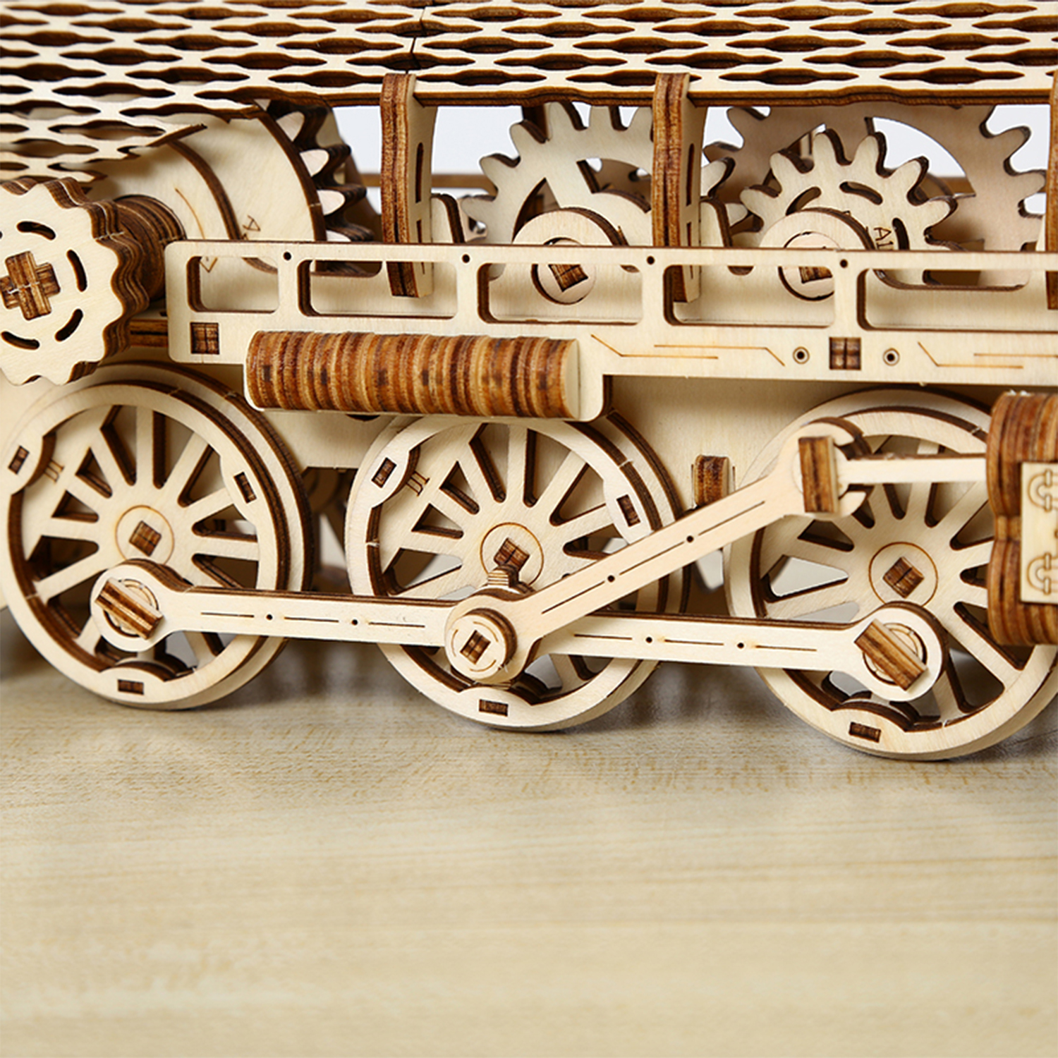 Modello in legno di locomotiva a vapore con ingranaggi e ruote visibili.