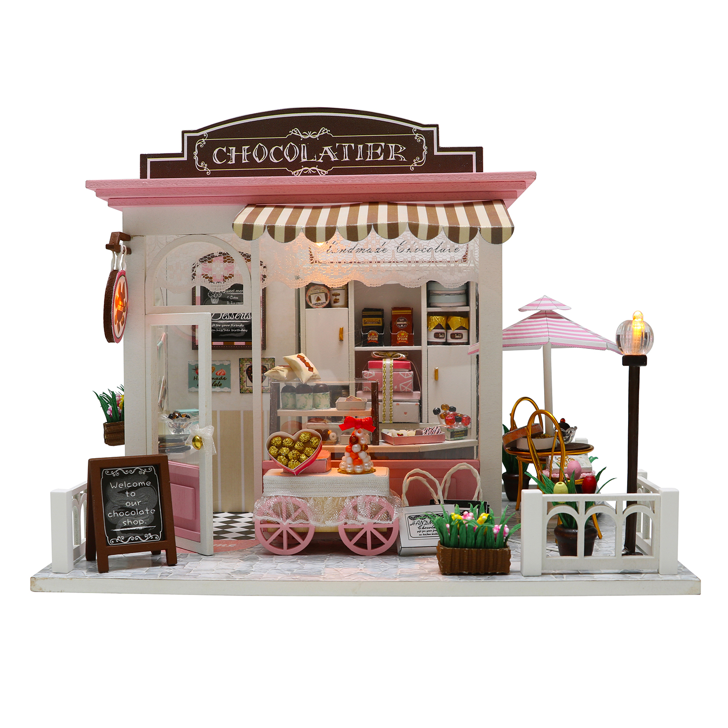 Negozio di cioccolataio in miniatura con accenti rosa e bianchi, cioccolatini e fiori.