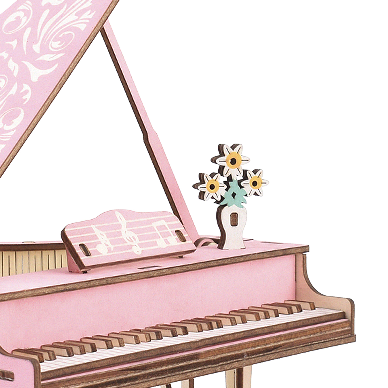 Un pianoforte a coda giocattolo rosa con leggio e fiori in vaso.