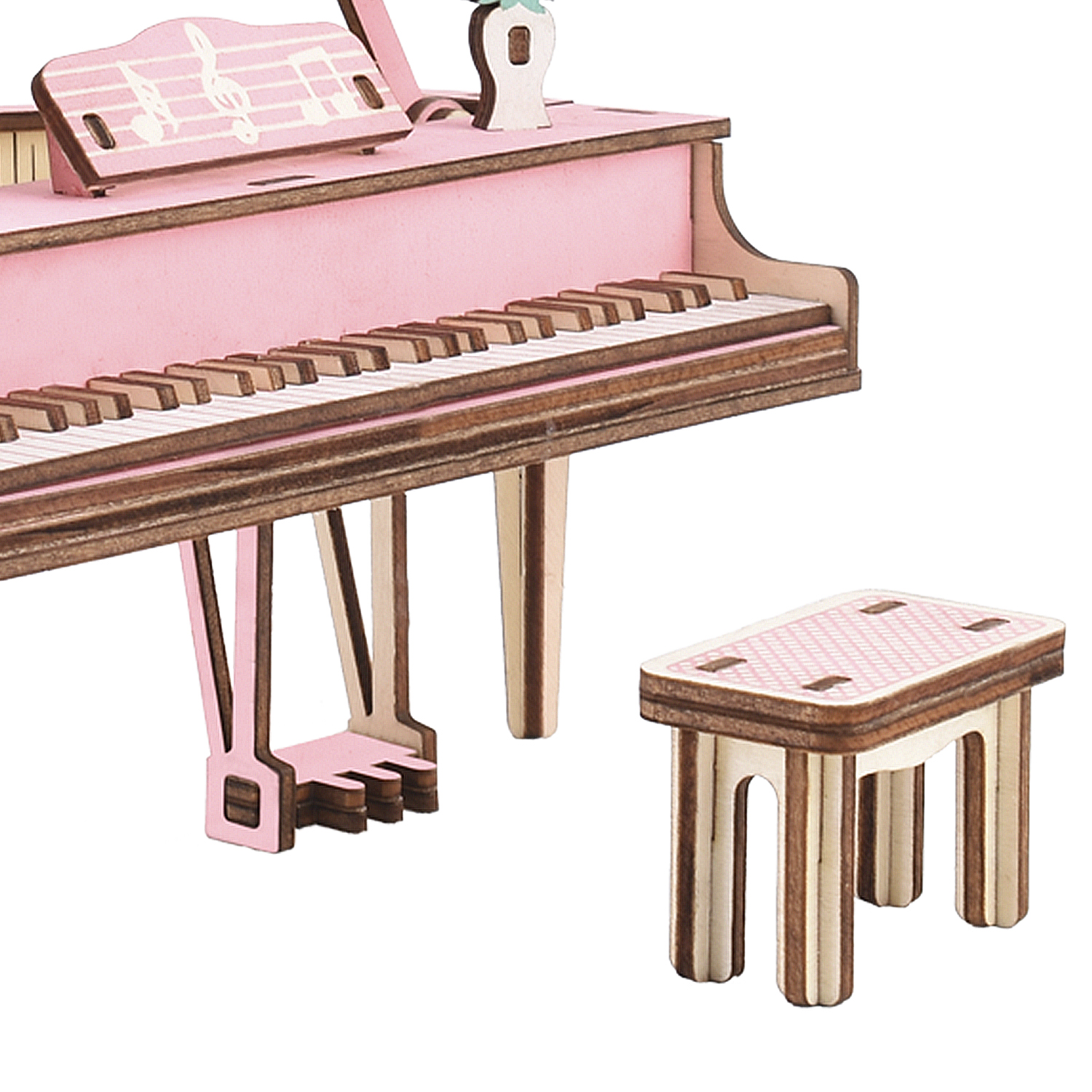 Un pianoforte a coda in miniatura rosa con leggio e sgabello accanto.