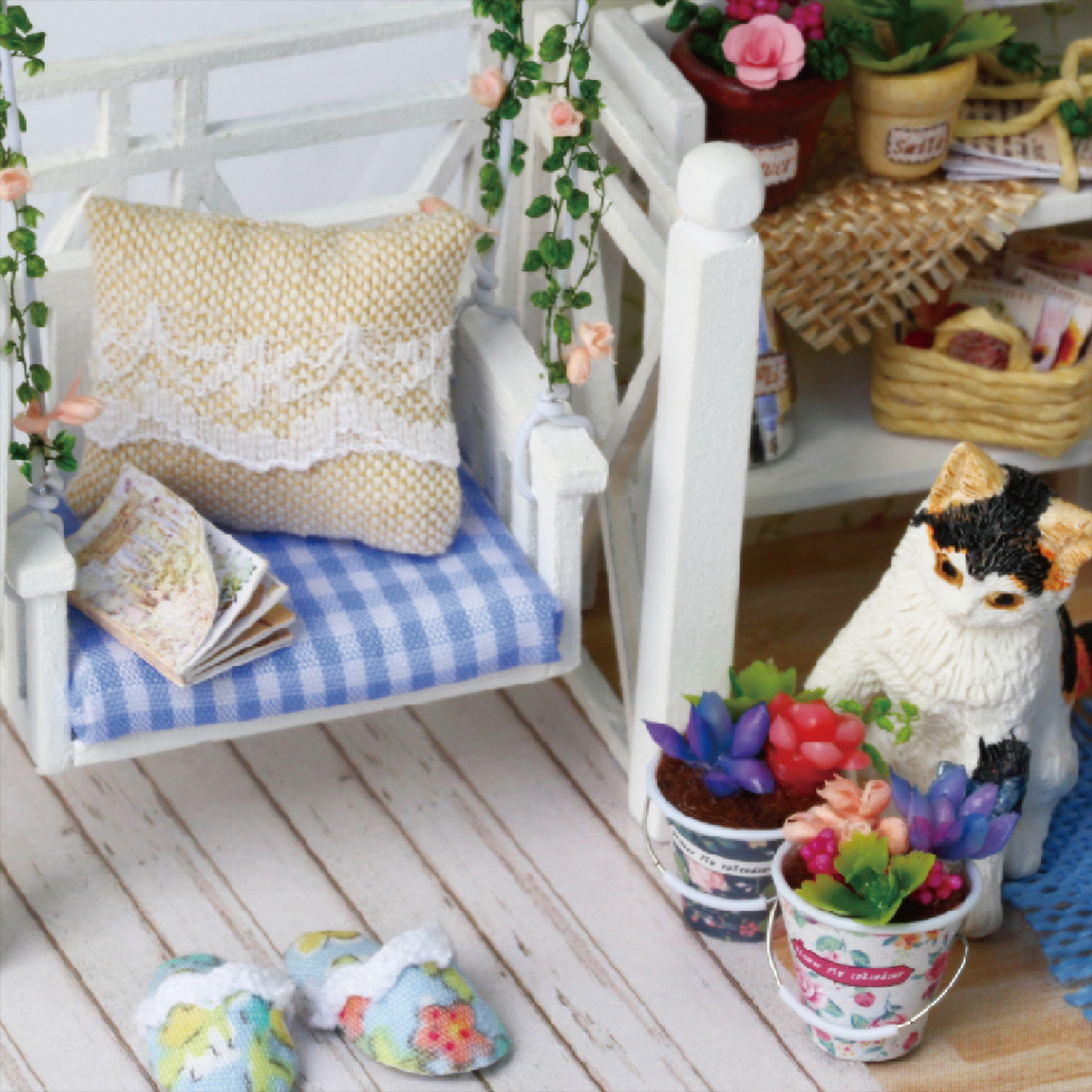 Portico in miniatura con sedia a dondolo, cuscino, pantofole, gatto e piante.